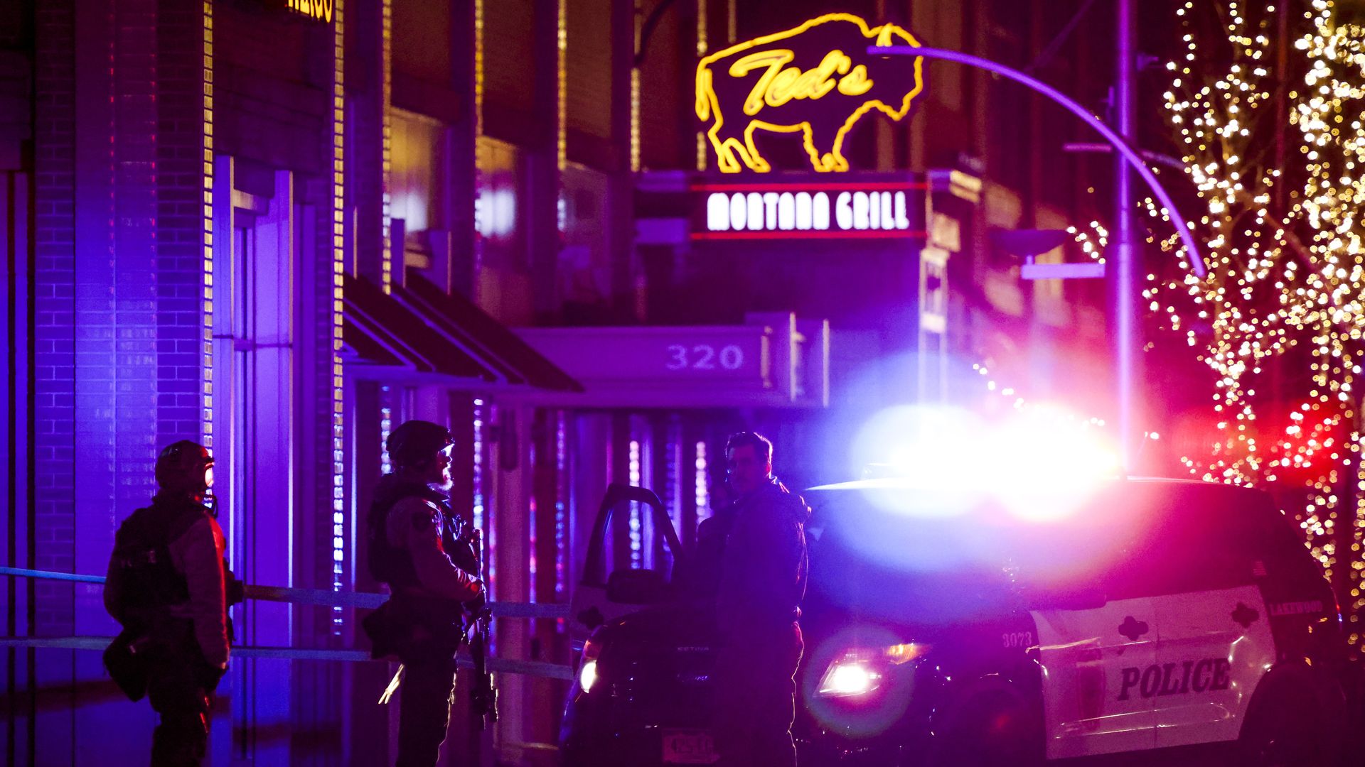   Police stand outside the Belmar shopping center where they say the suspect in a shooting spree that claimed five lives was shot and killed on December 27, 2021 in Lakewood, Colorado. 