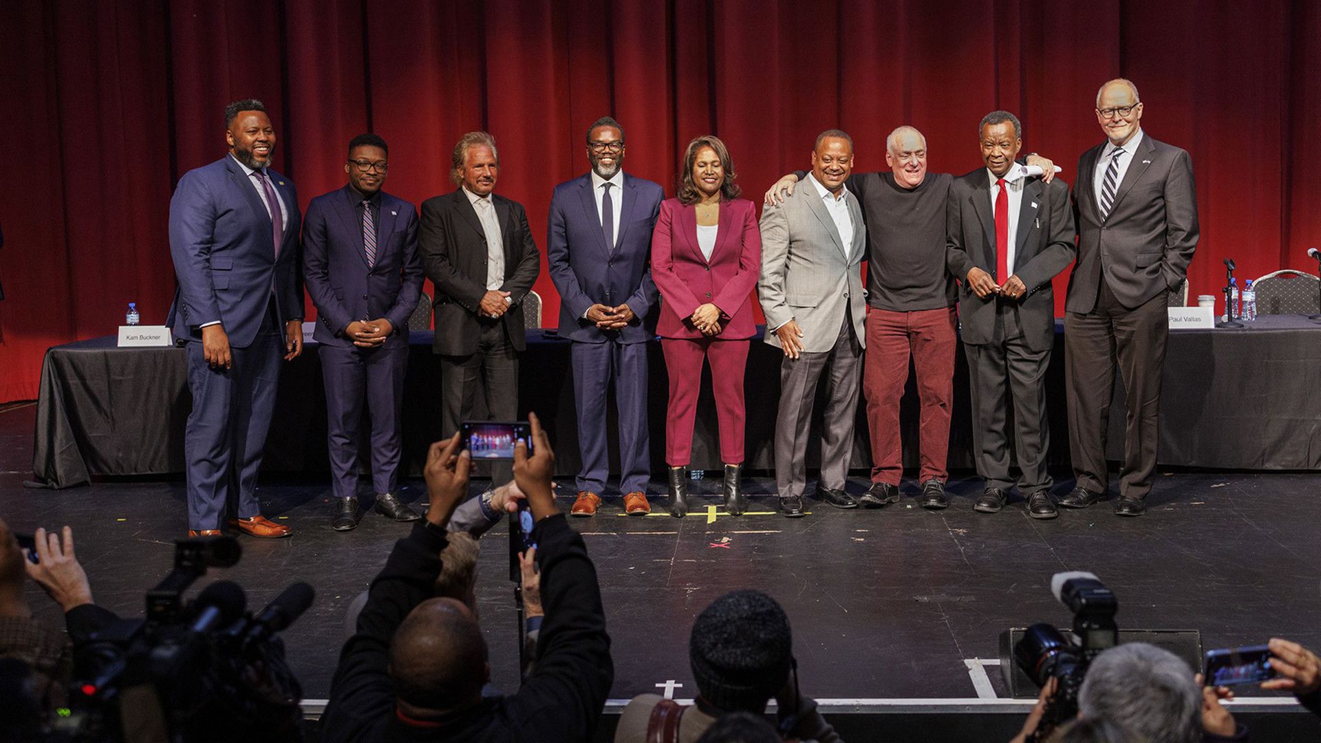 Photo of a bunch of people posing for photos on a stage.