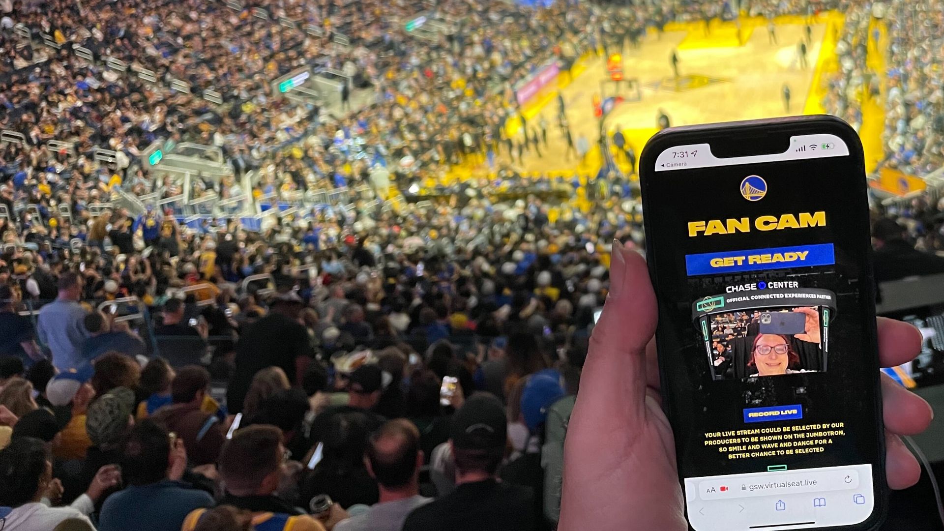 A picture of the Warriors Fan Cam app running on a smartphone with Chase Center in the background