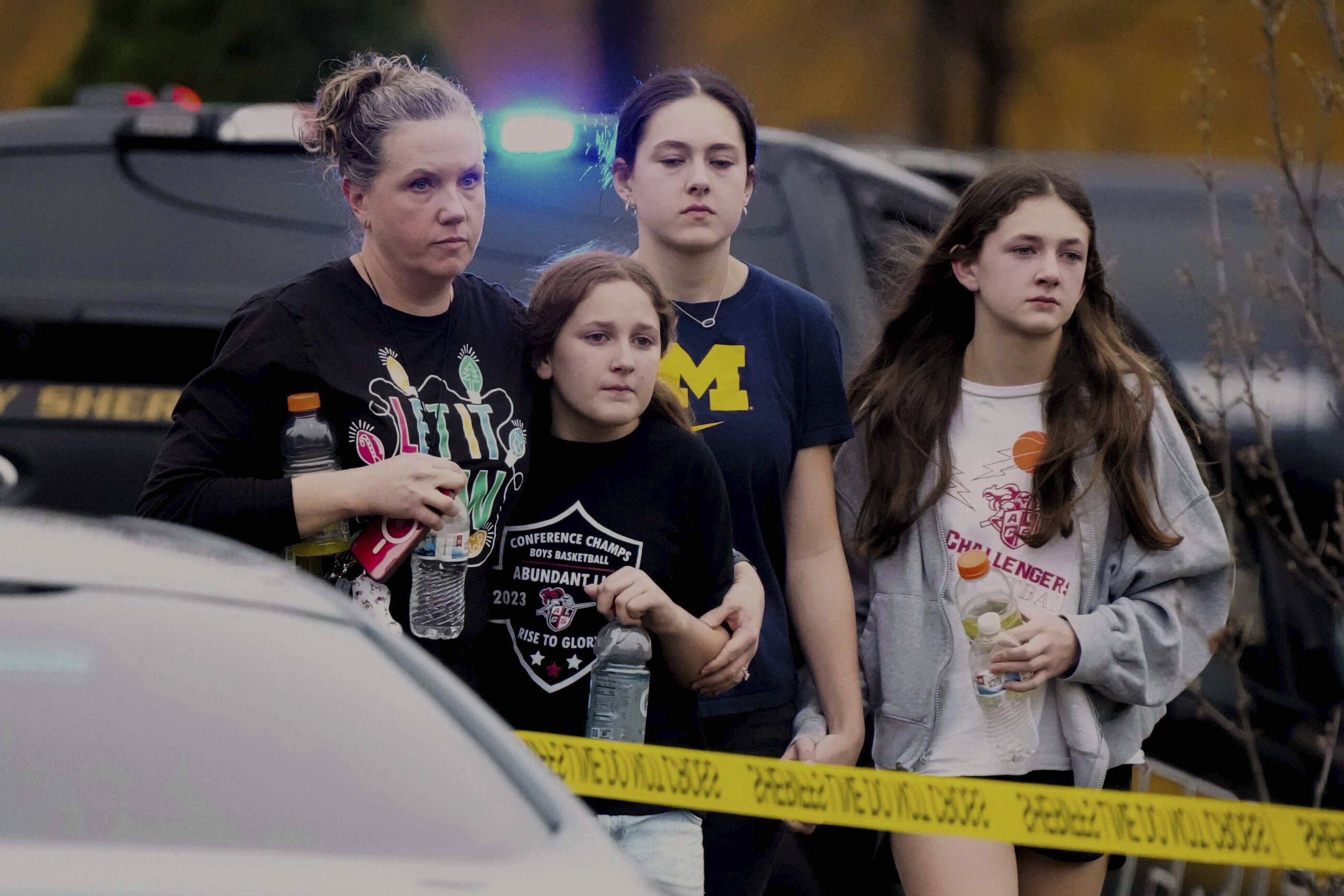 A family leaves a reunification center after a shooting yesterday at the Abundant Life Christian School in Madison, Wis.