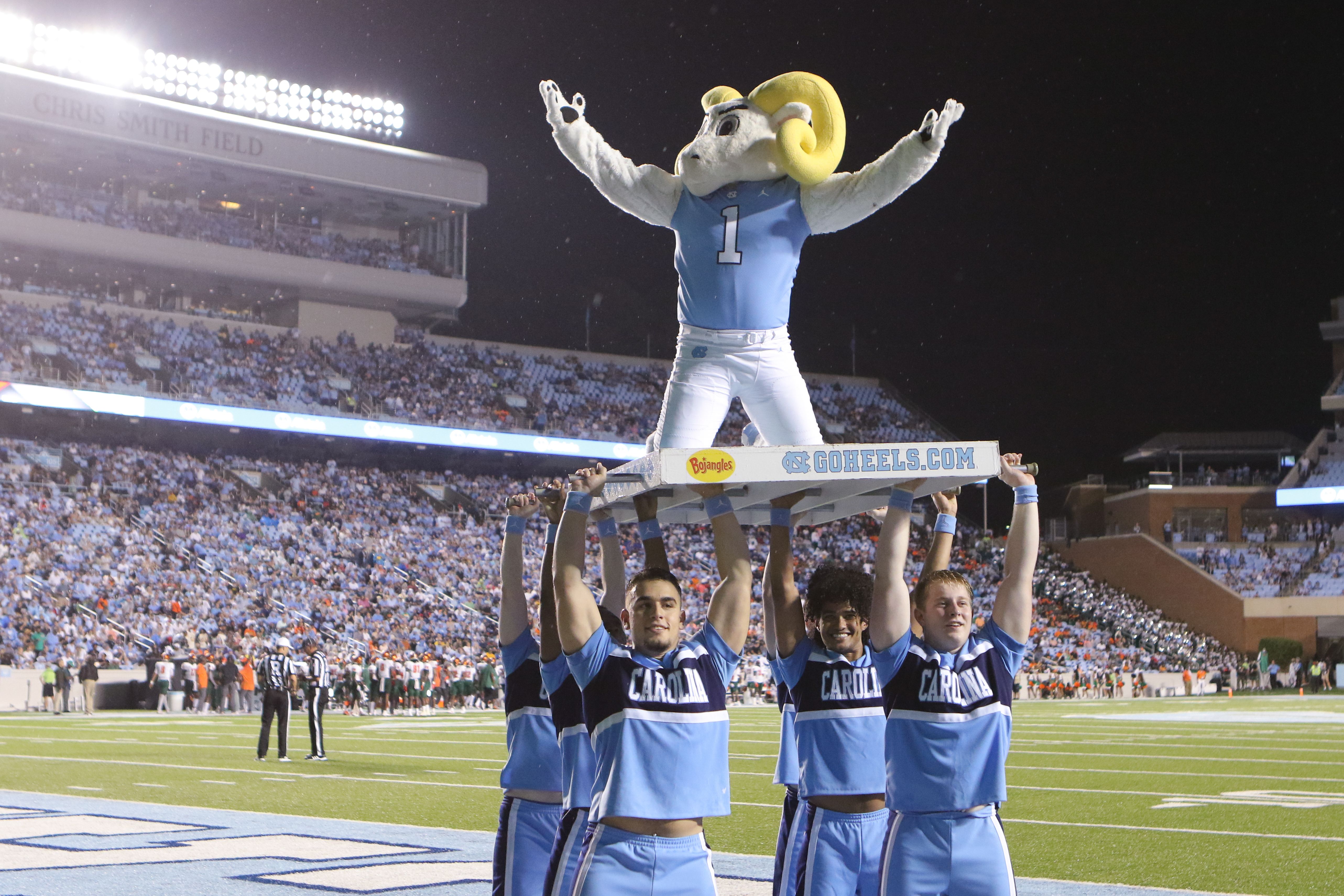 unc football cheerleaders and mascot posing on the field
