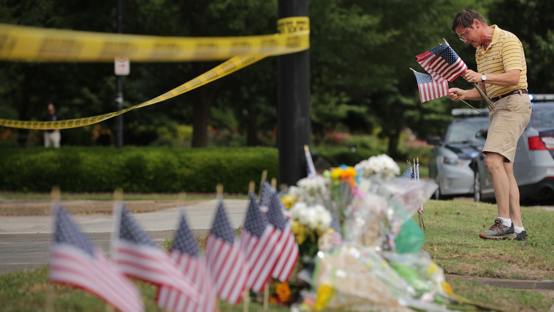 Rich Lindgren places 12 U.S. flags in the ground at a makeshif memorial outside of the crime scene at the Virginia Beach Municipal Center June 01, 2019 in Virginia Beach, Virginia.