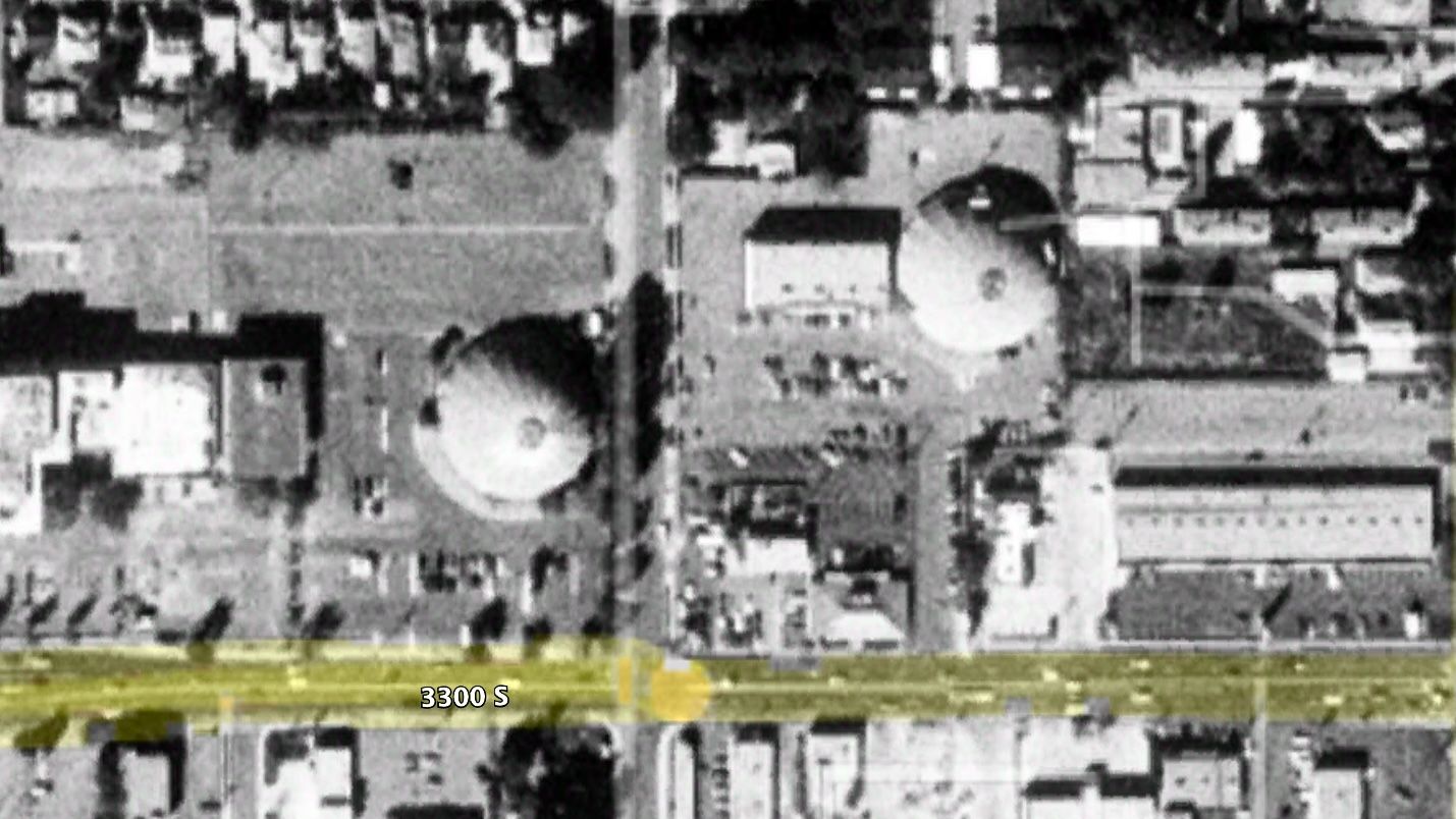 A black and white satellite image of two domed buildings in a city.