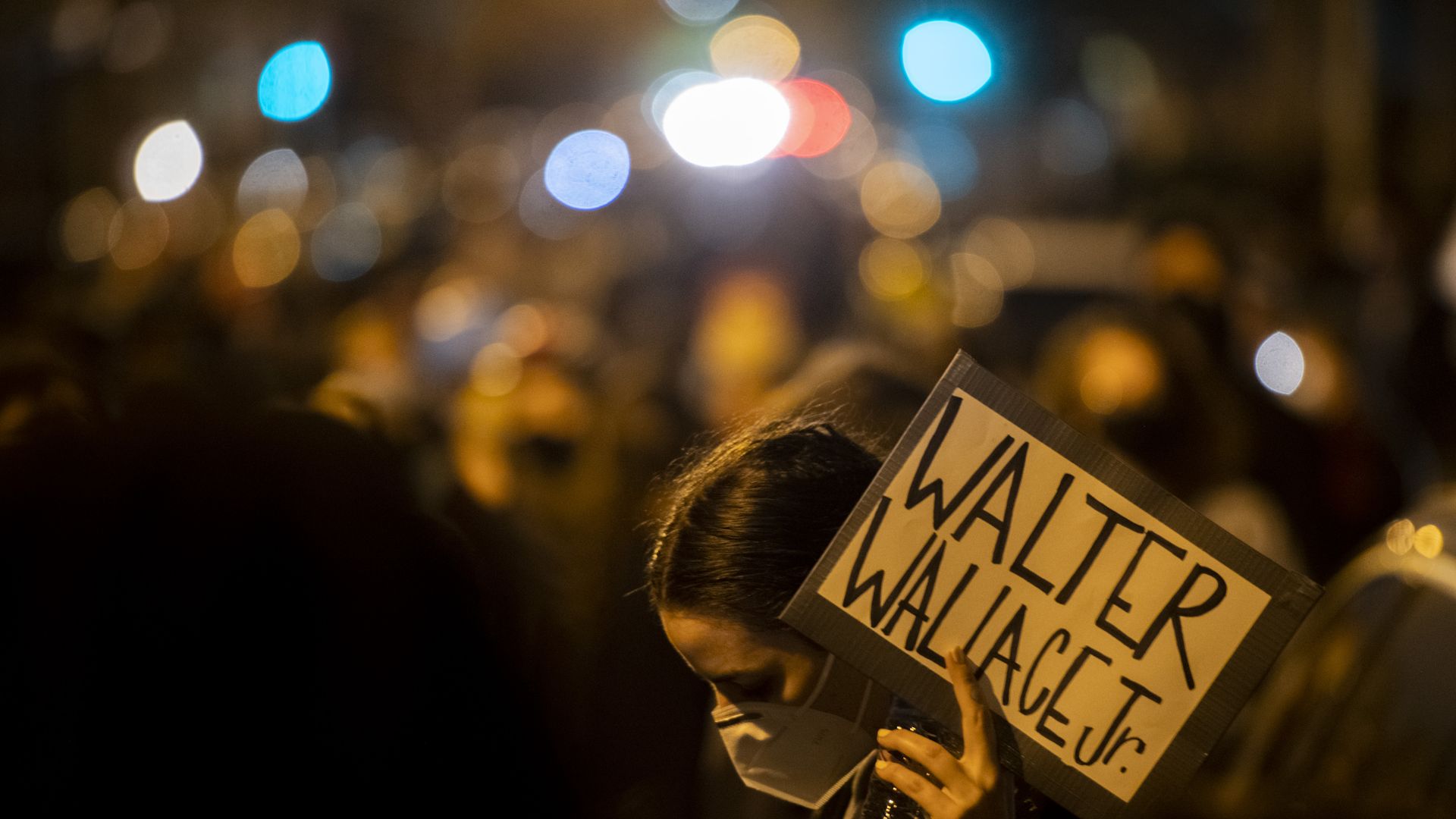 A demonstrator holds a placard reading "WALTER WALLACE JR." during a protest in Philadelphia.
