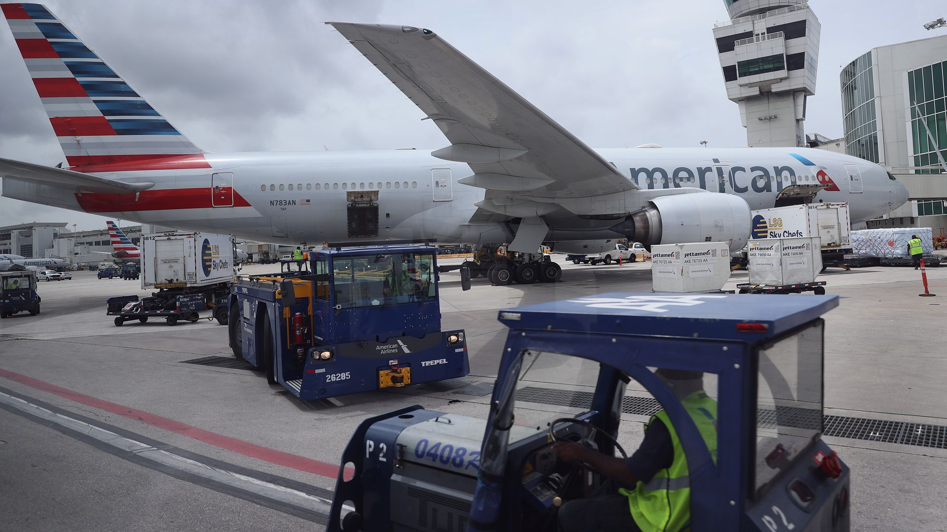 Workers prepare an American Airlines plane at a gate before its flight from the Miami International Airport on June 16, 2021 in Miami, Florida.