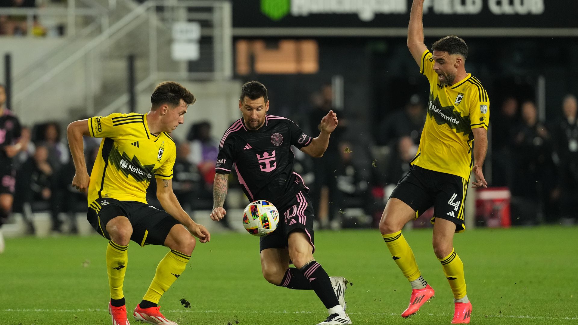 Inter Miami's Lionel Messi dribbles between two Columbus Crew defenders