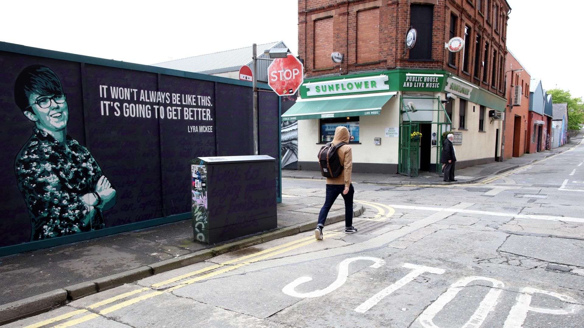 A resident cycles past a mural featuring murdered journalist Lyra McKee.
