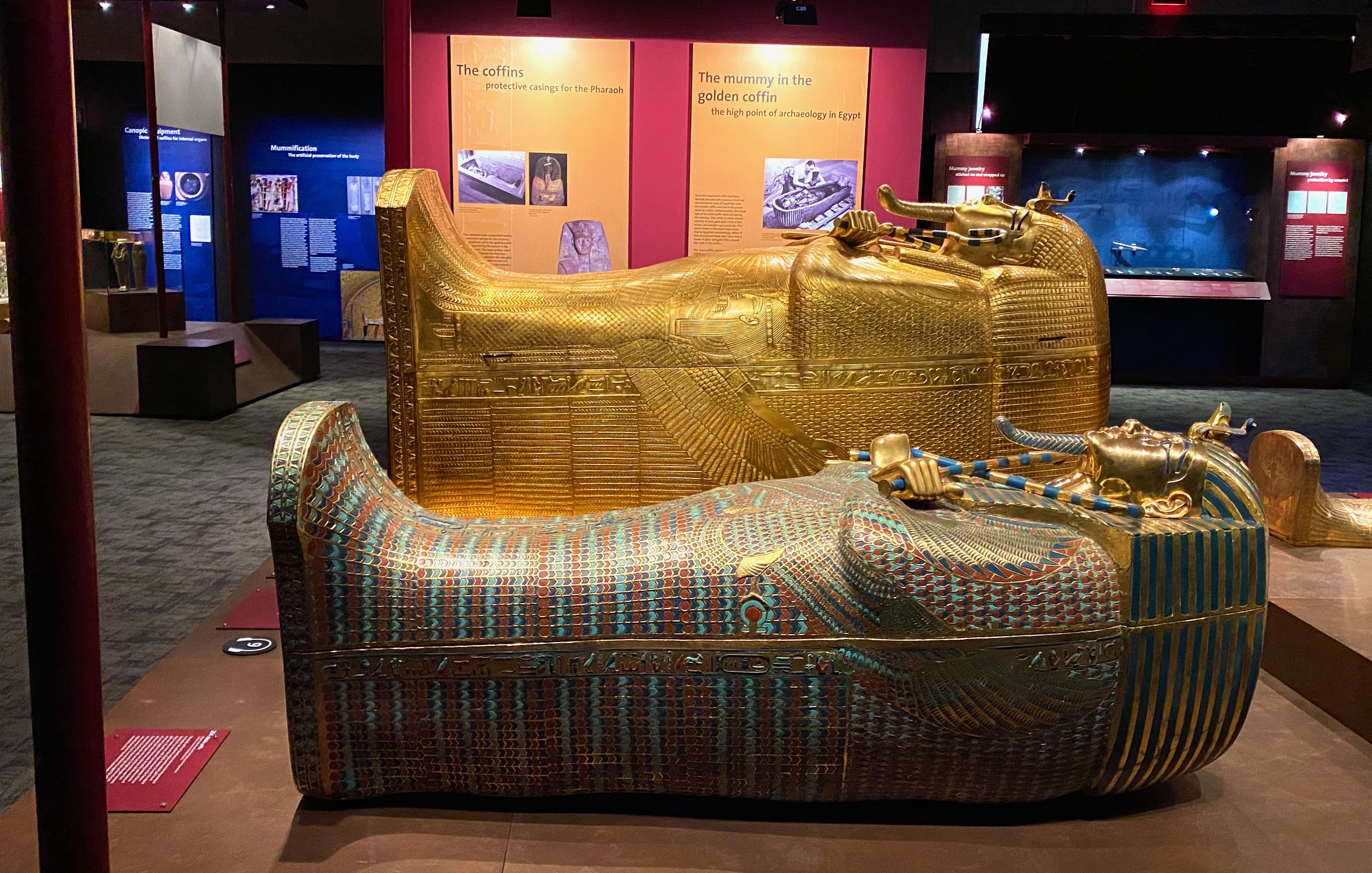 Two replica coffins shaped like Tutankhamun laying on their backs