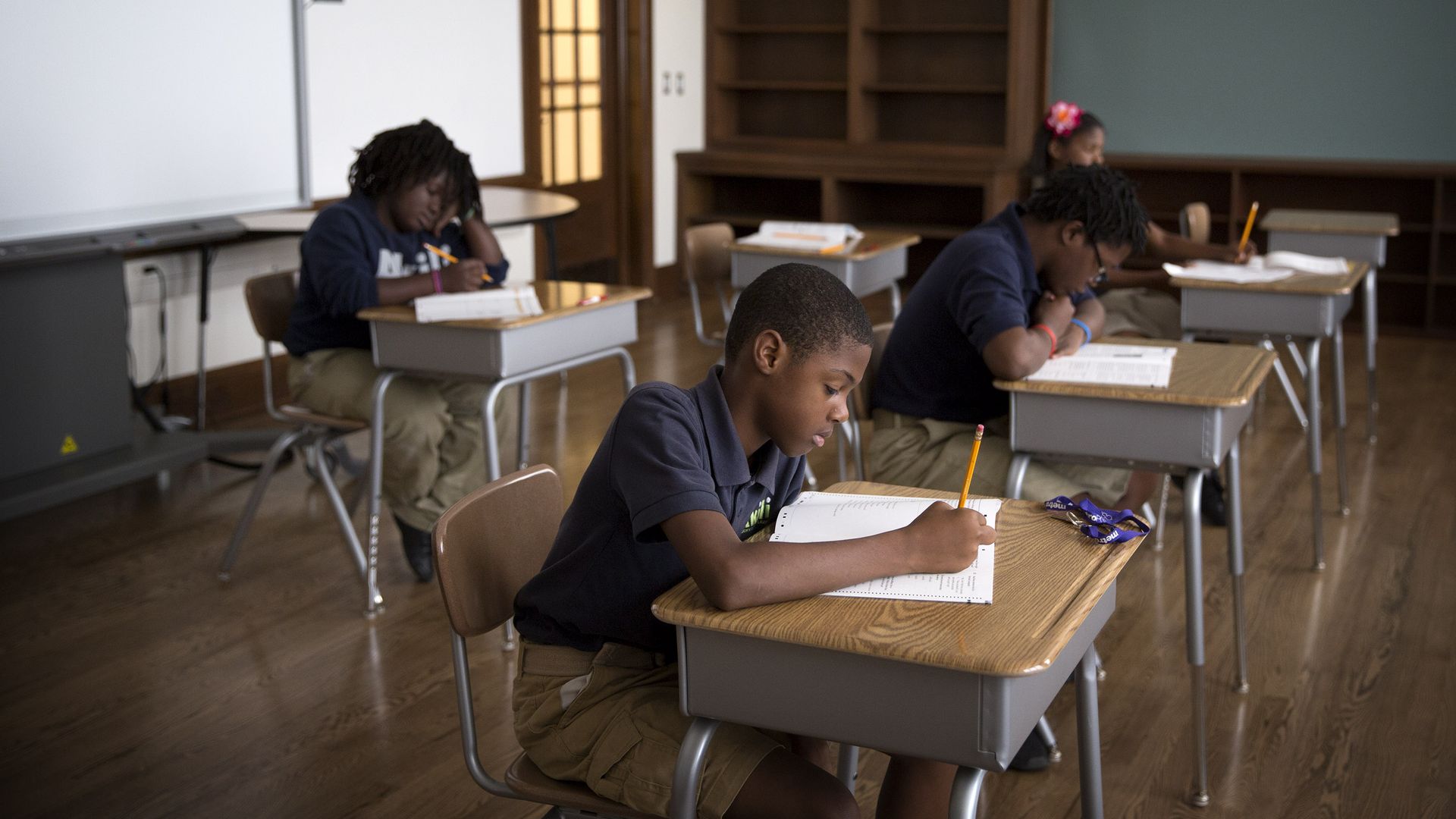 Photo of four students taking a standardized test in a classroom