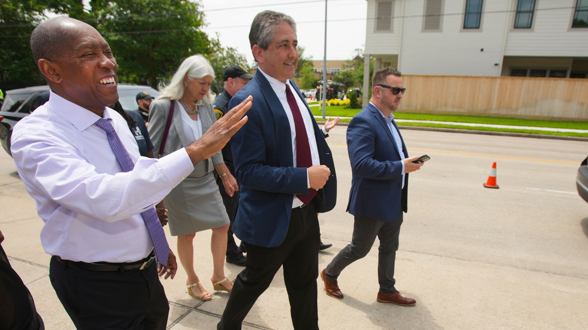 Several people, including former Houston Mayor Sylvester Turner and former chief transportation planner David Fields, walk along the street 