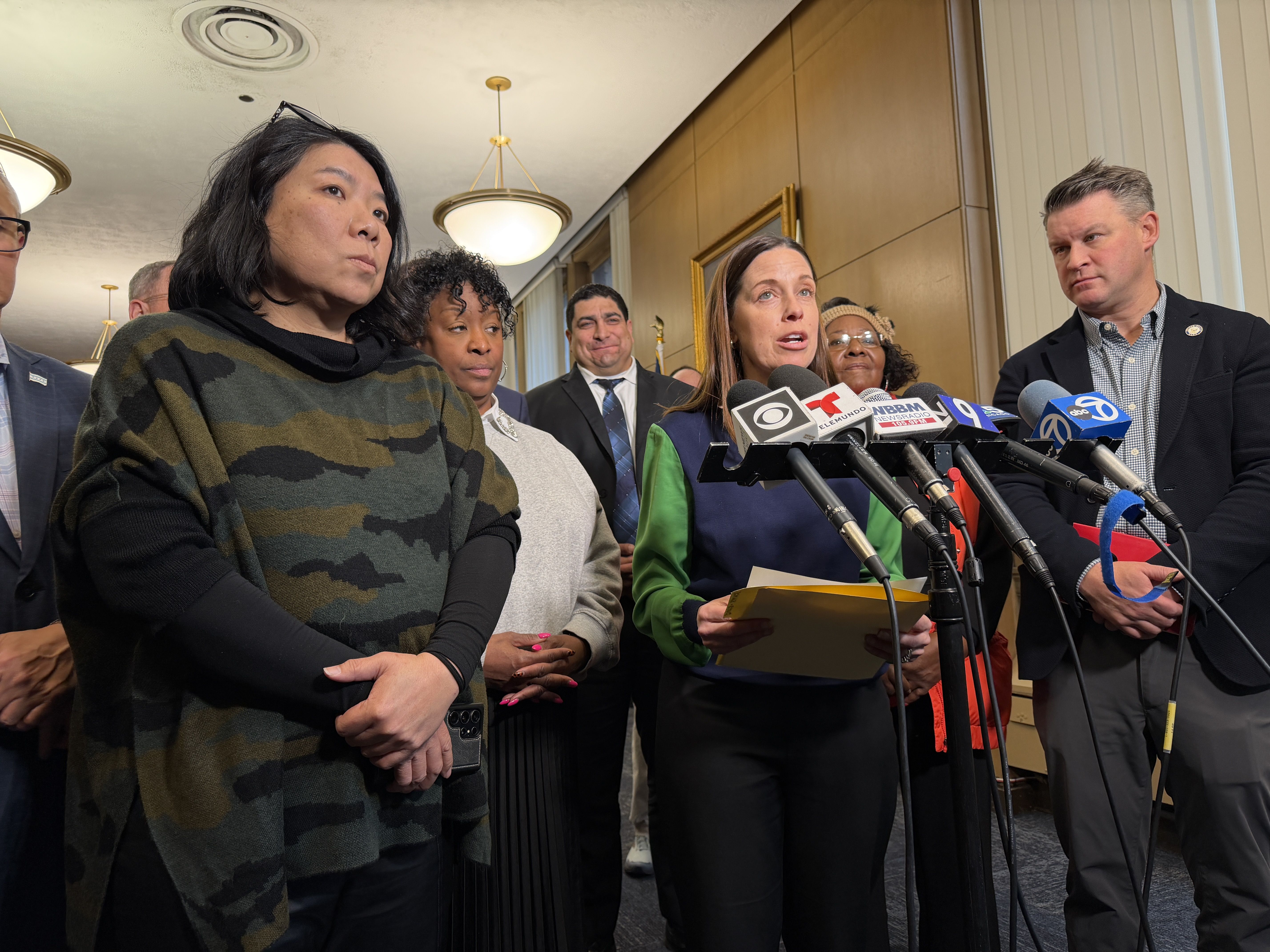 People standing in front of microphones. 
