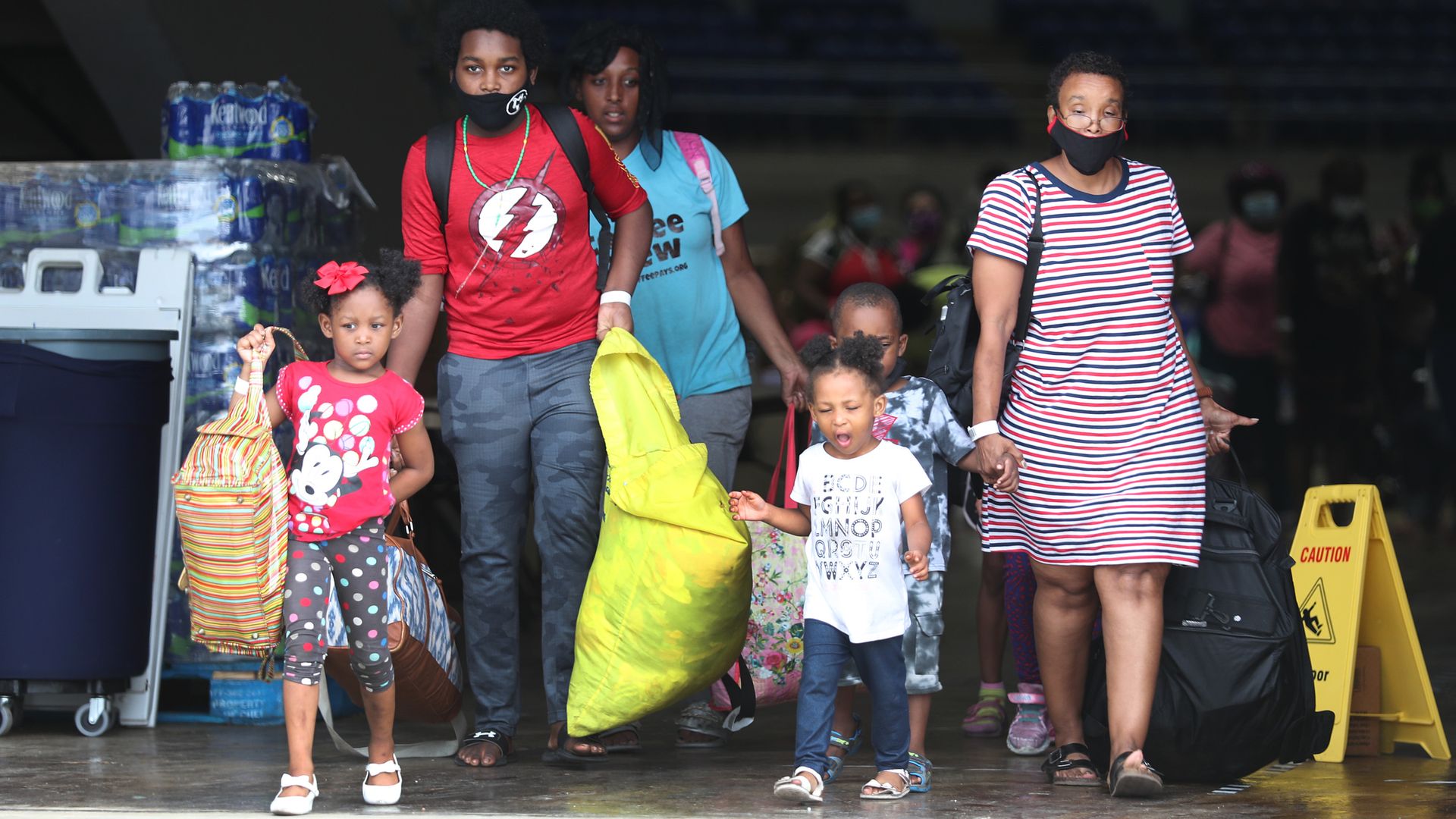 Evacuees walk to board a bus as they are evacuated by local and state government officials before the arrival of Hurricane Laura on August 25, 2020 in Lake Charles, Louisiana.