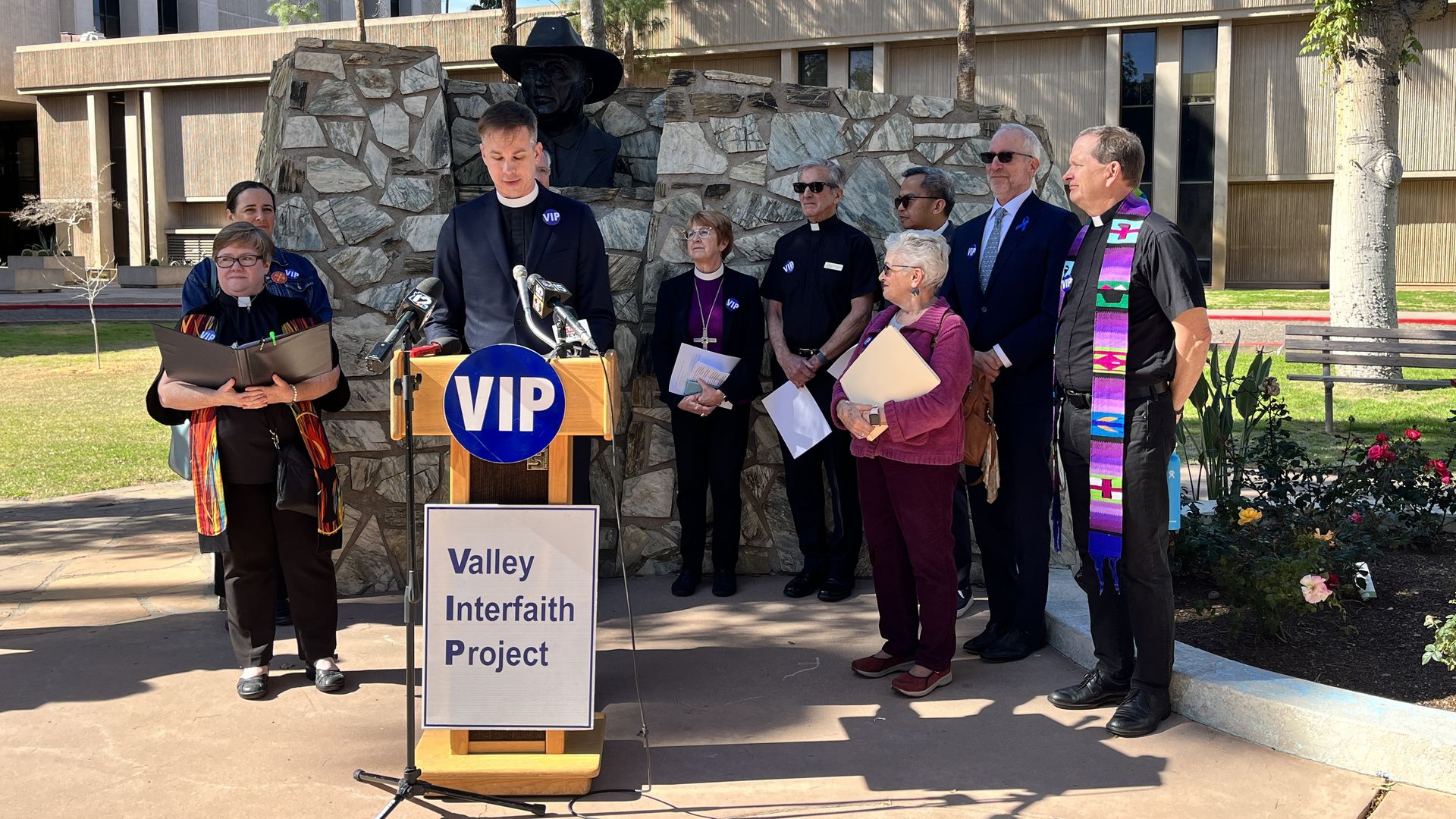 People wearing religious regalia at a podium. 