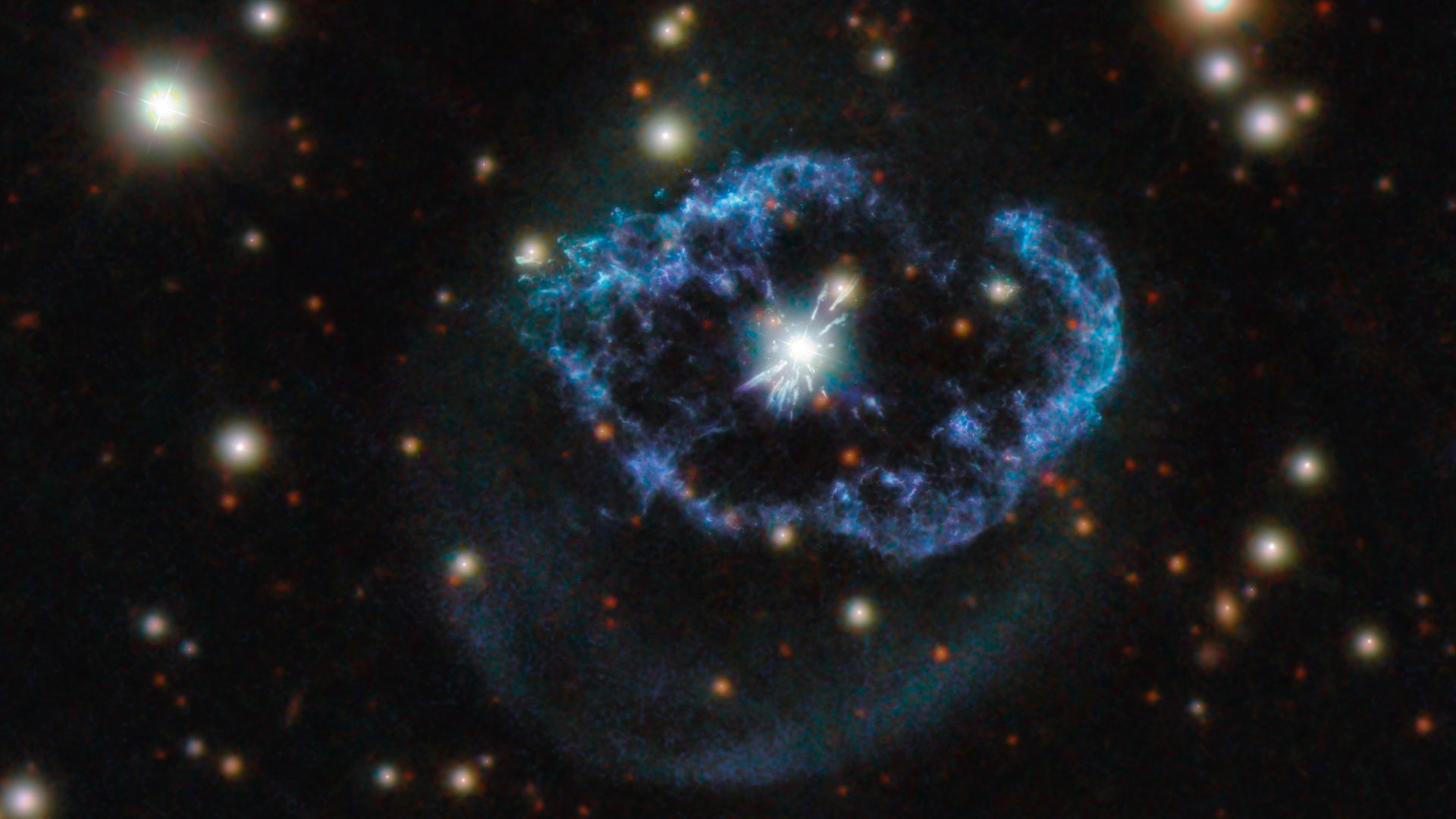 A blue ring circling a white star in deep space, with other yellow stars sprinkled around