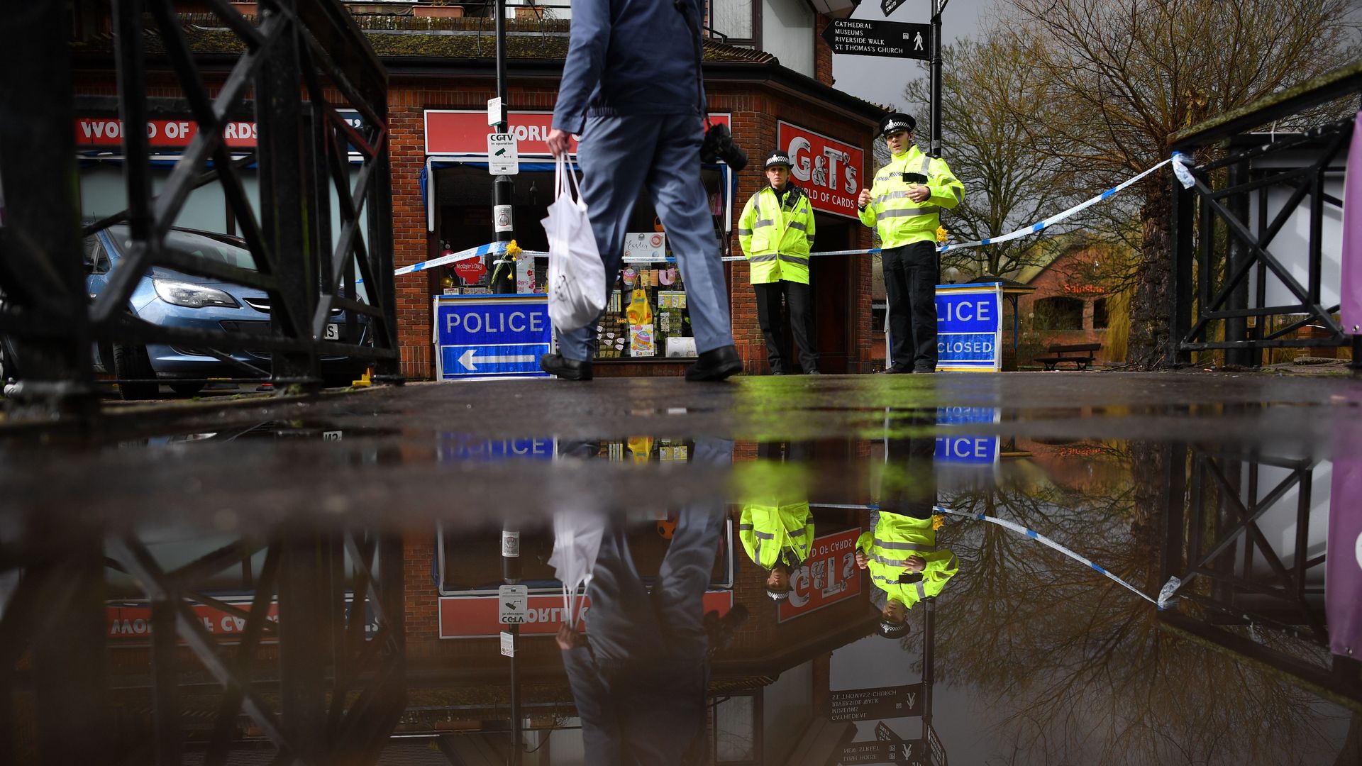 water on a sidewalk with british cops in the background
