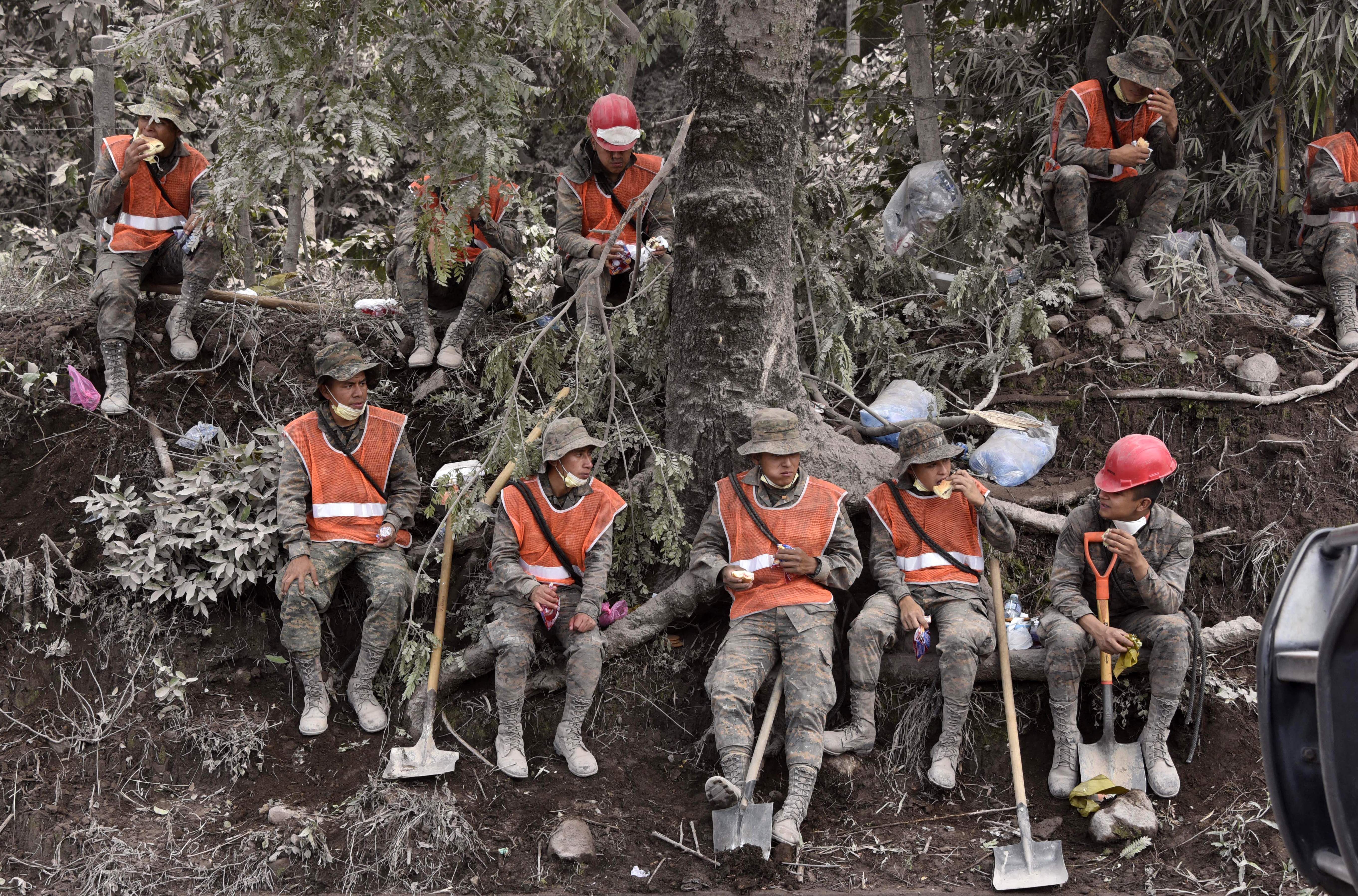 Soldiers take a break during the search for victims
