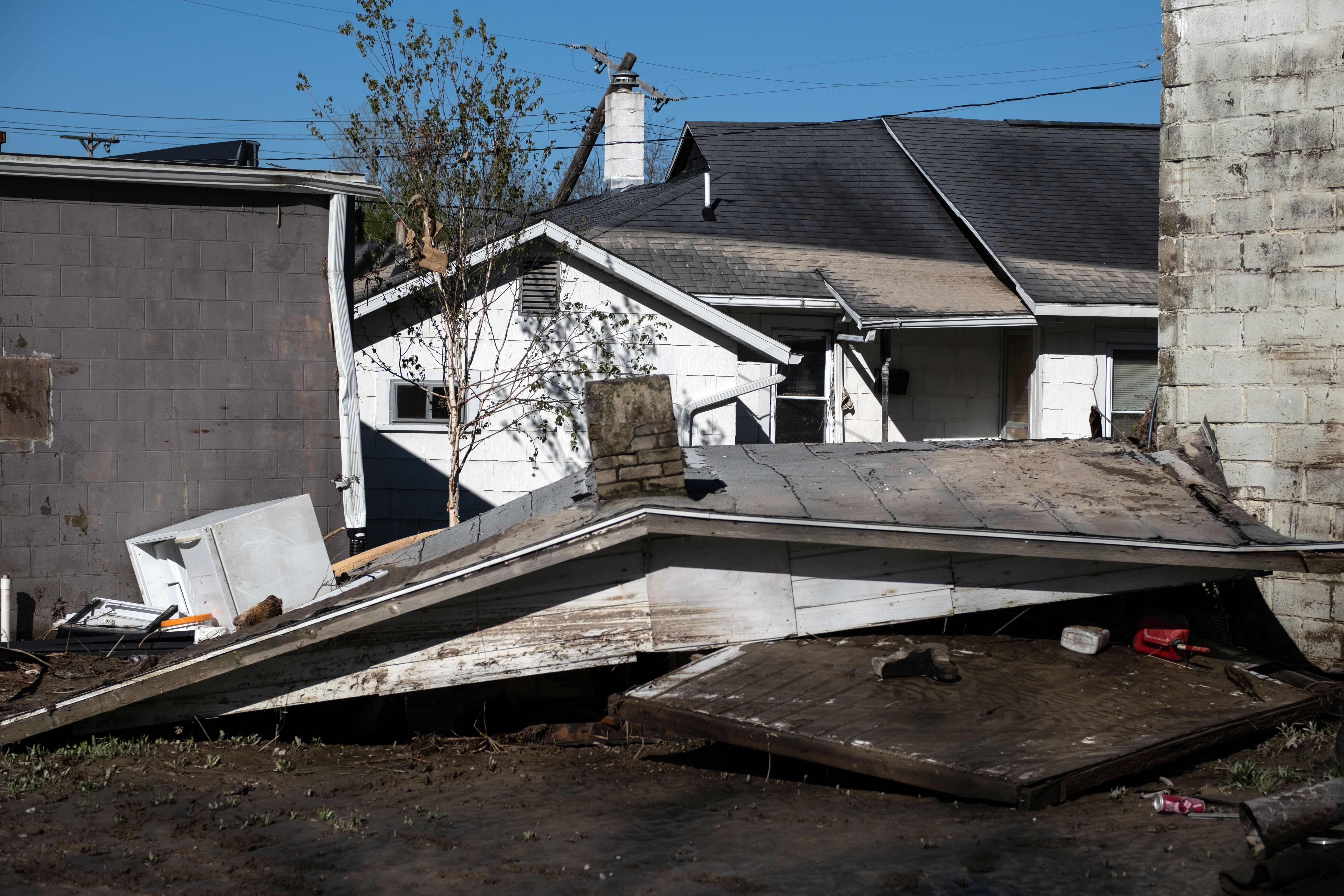 In this image, a dislodged roof sits between two houses