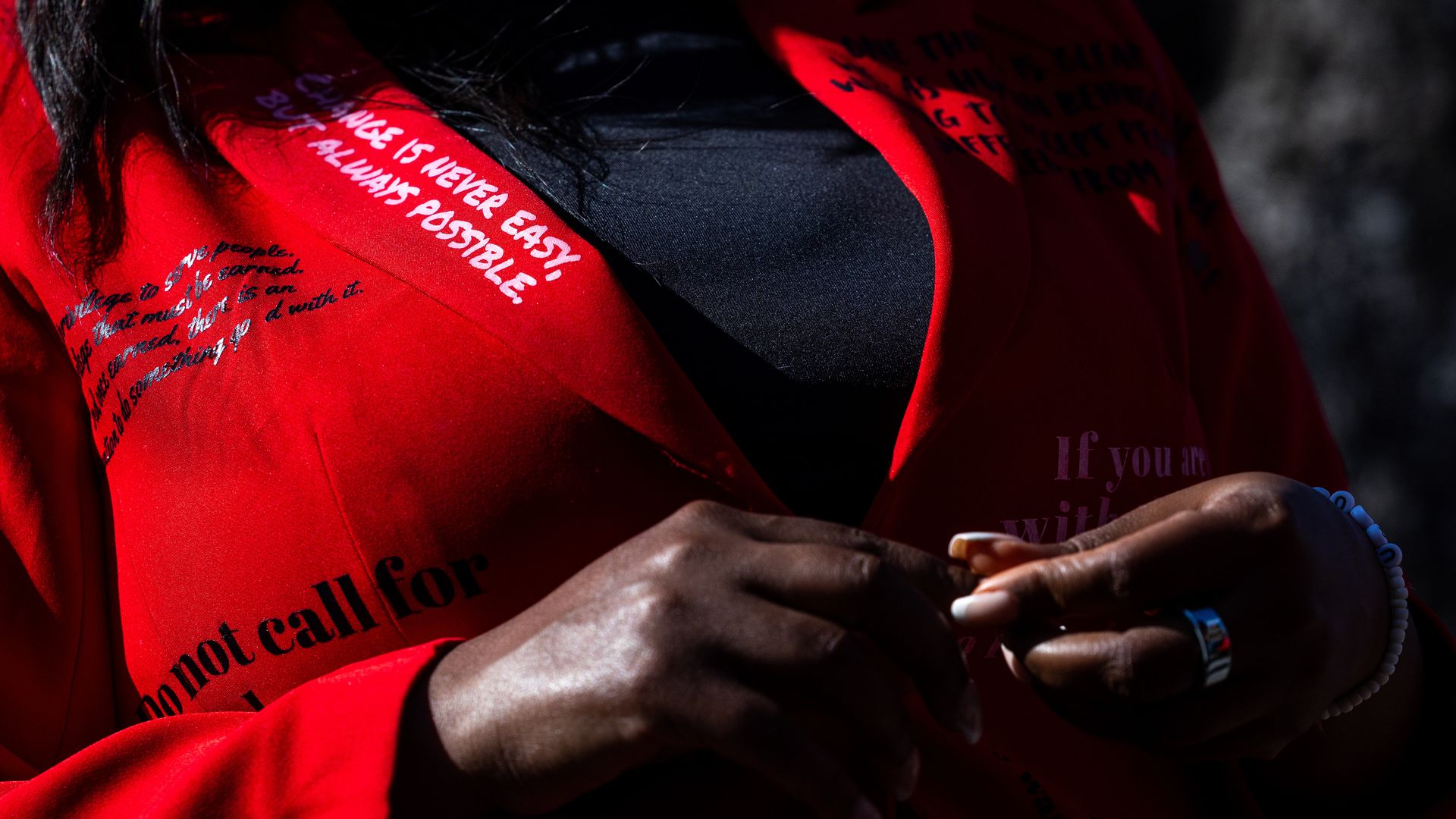 U.S. Rep. Jasmine Crockett wears a read blazer with quotes written on it.