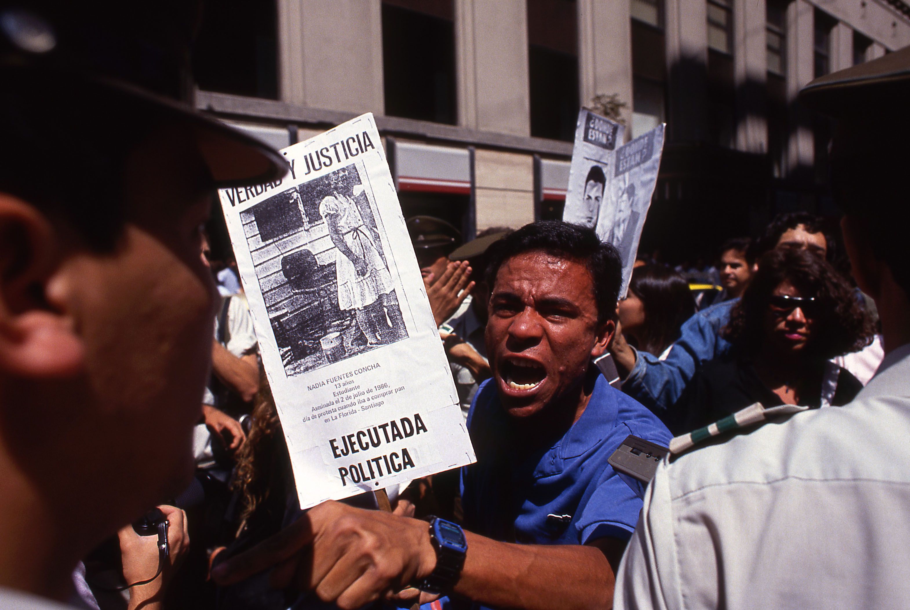 a protester in a blue shirt screams angrily at police during anti-government protest in Chile in 1988