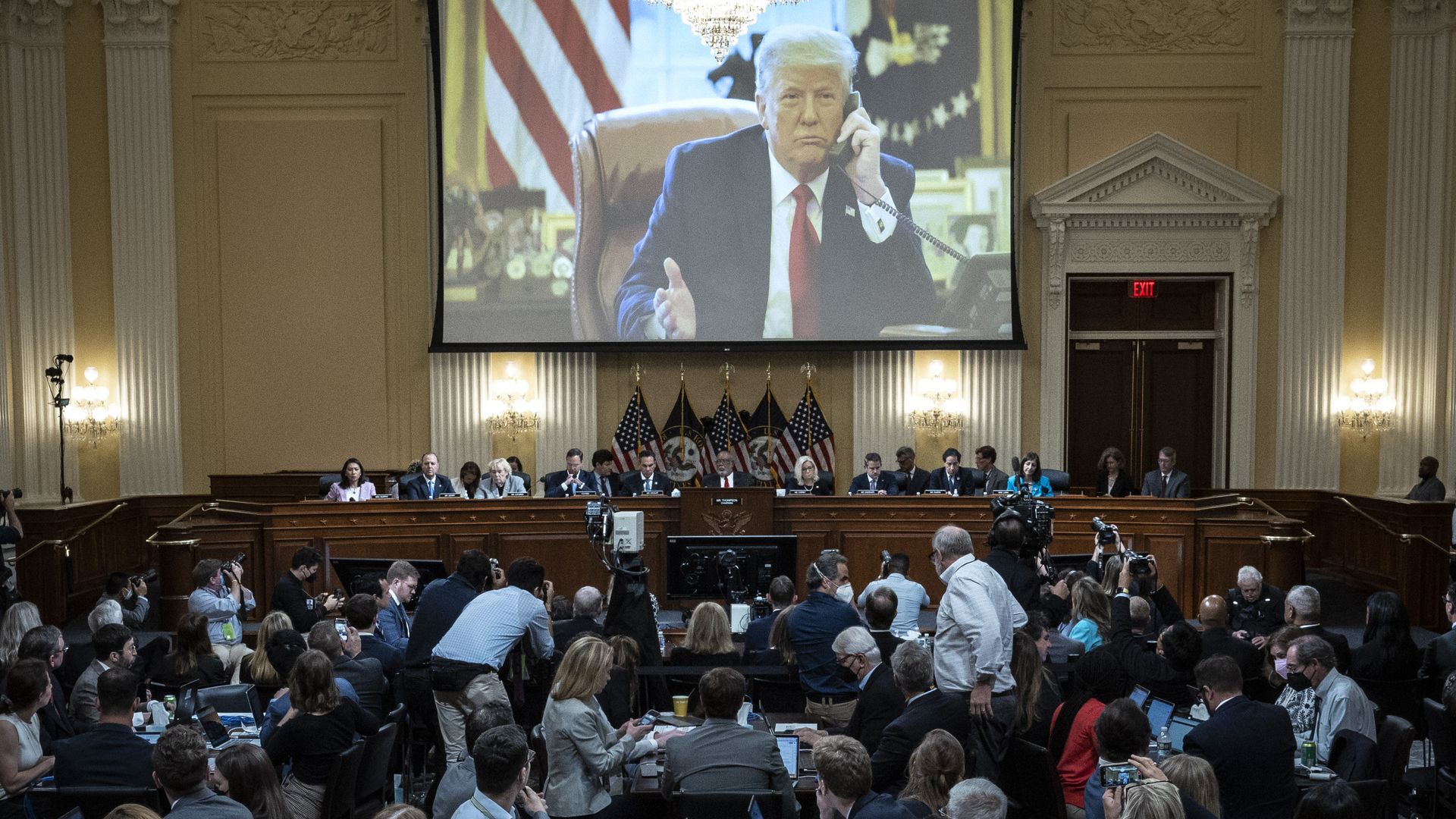 Photo of Donald Trump on a huge screen unfurled over the Jan. 6 committee in a packed hearing room