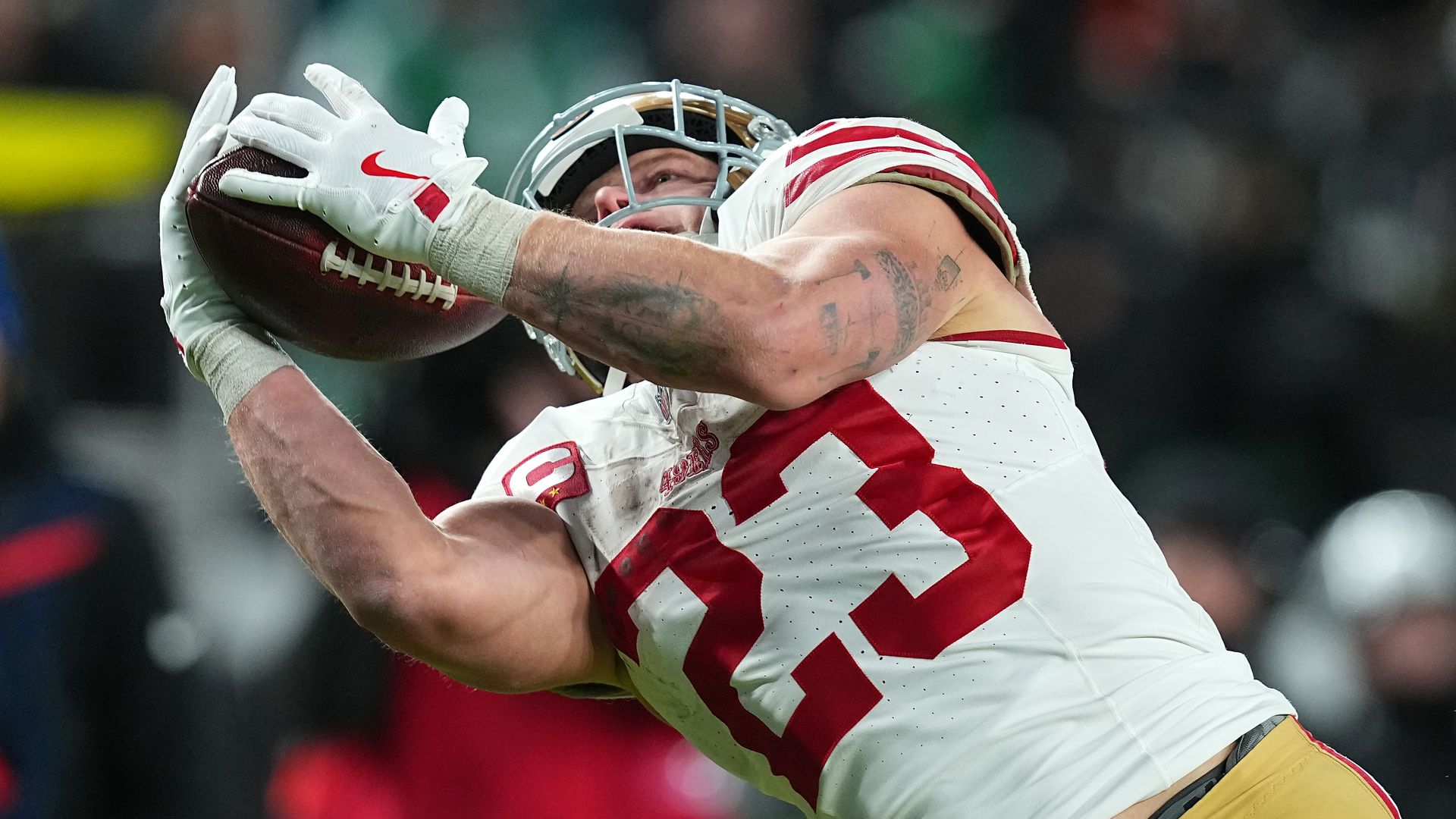 Photo of Christian McCaffrey diving with a football in his arms 