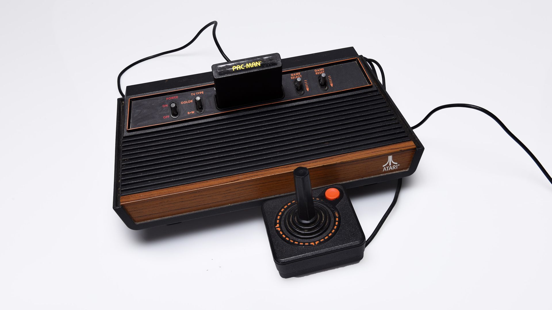 Photo of a black and brown video game console with a controller attached