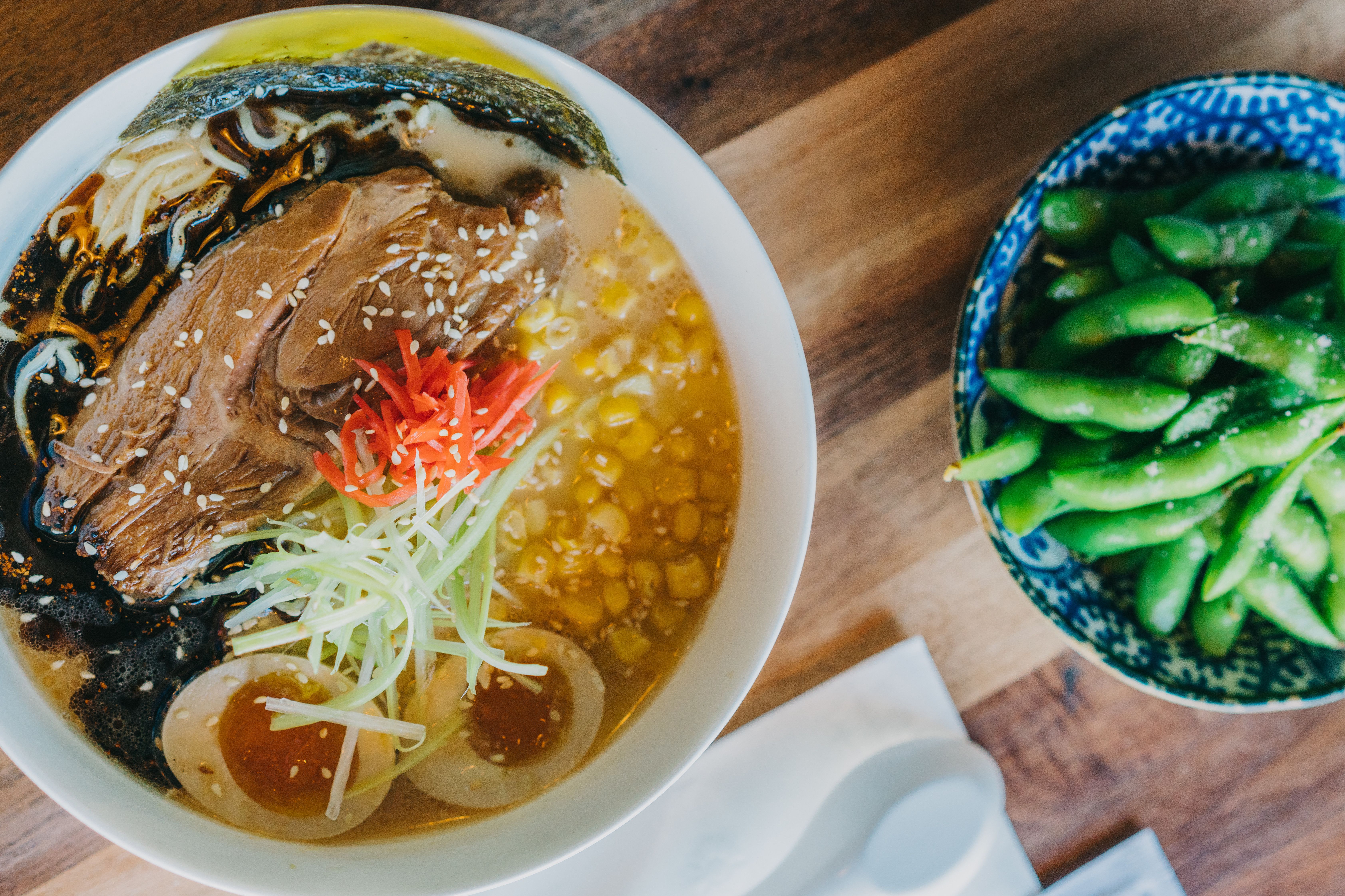 Photo shows a bowl of ramen and edamame