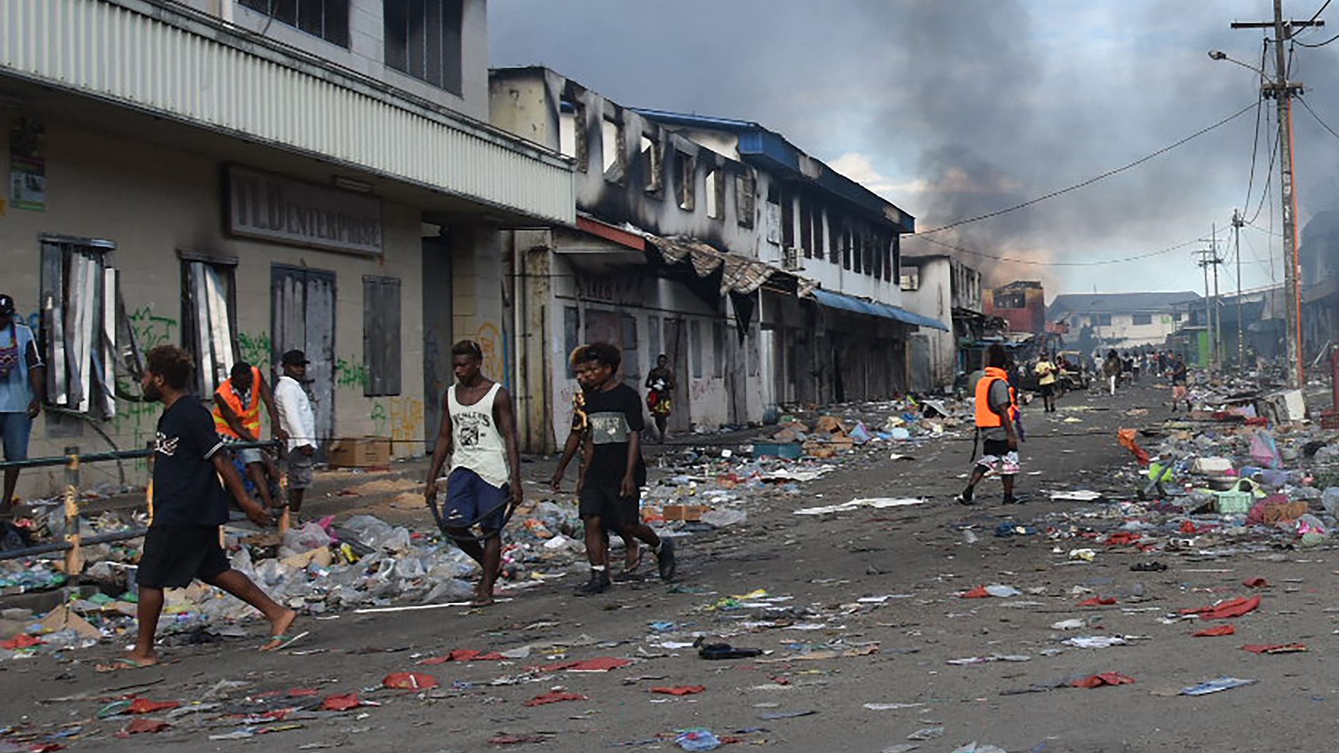 People walk through the Chinatown district of Honiara on the Solomon Islands on November 26, 2021, after a third day of violence