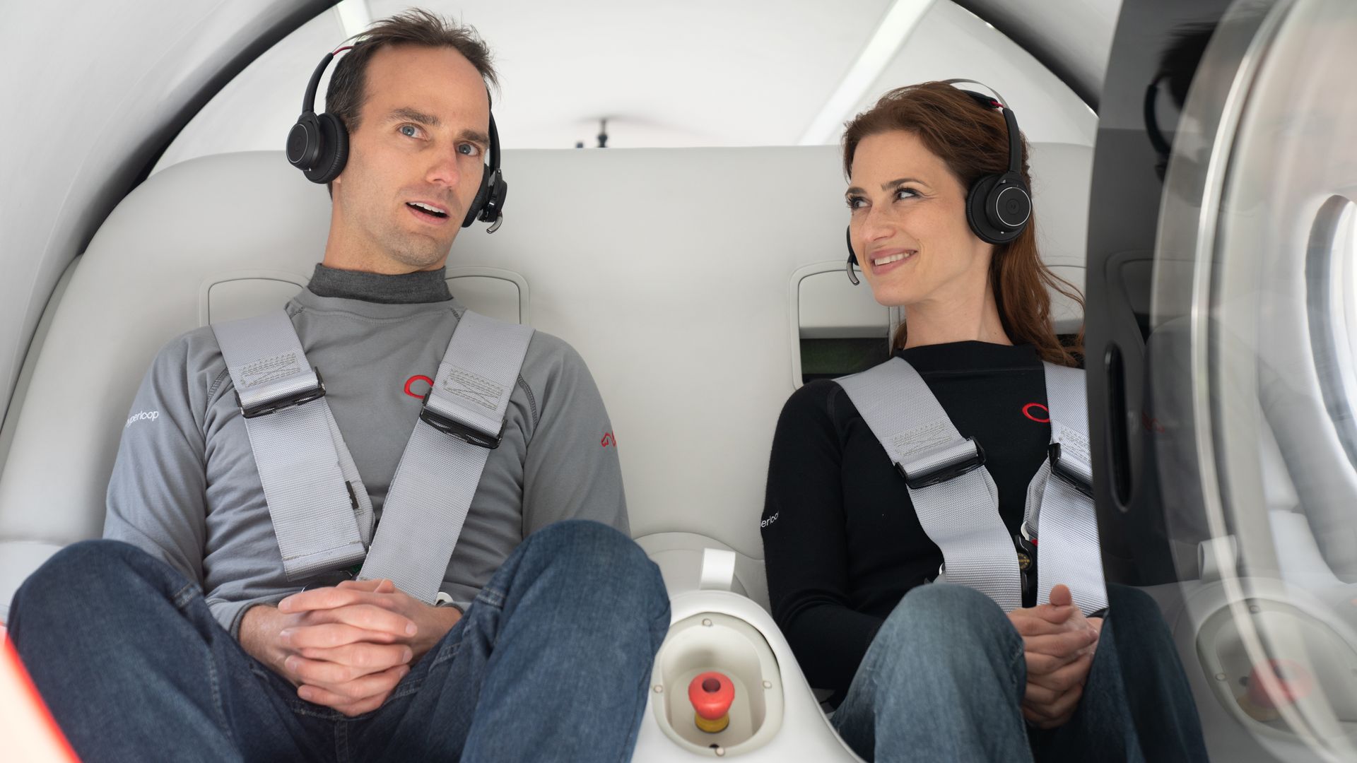 Image of a man and a woman buckled into Virgin Hyperloop's capsule for test run of high-speed transportation. 