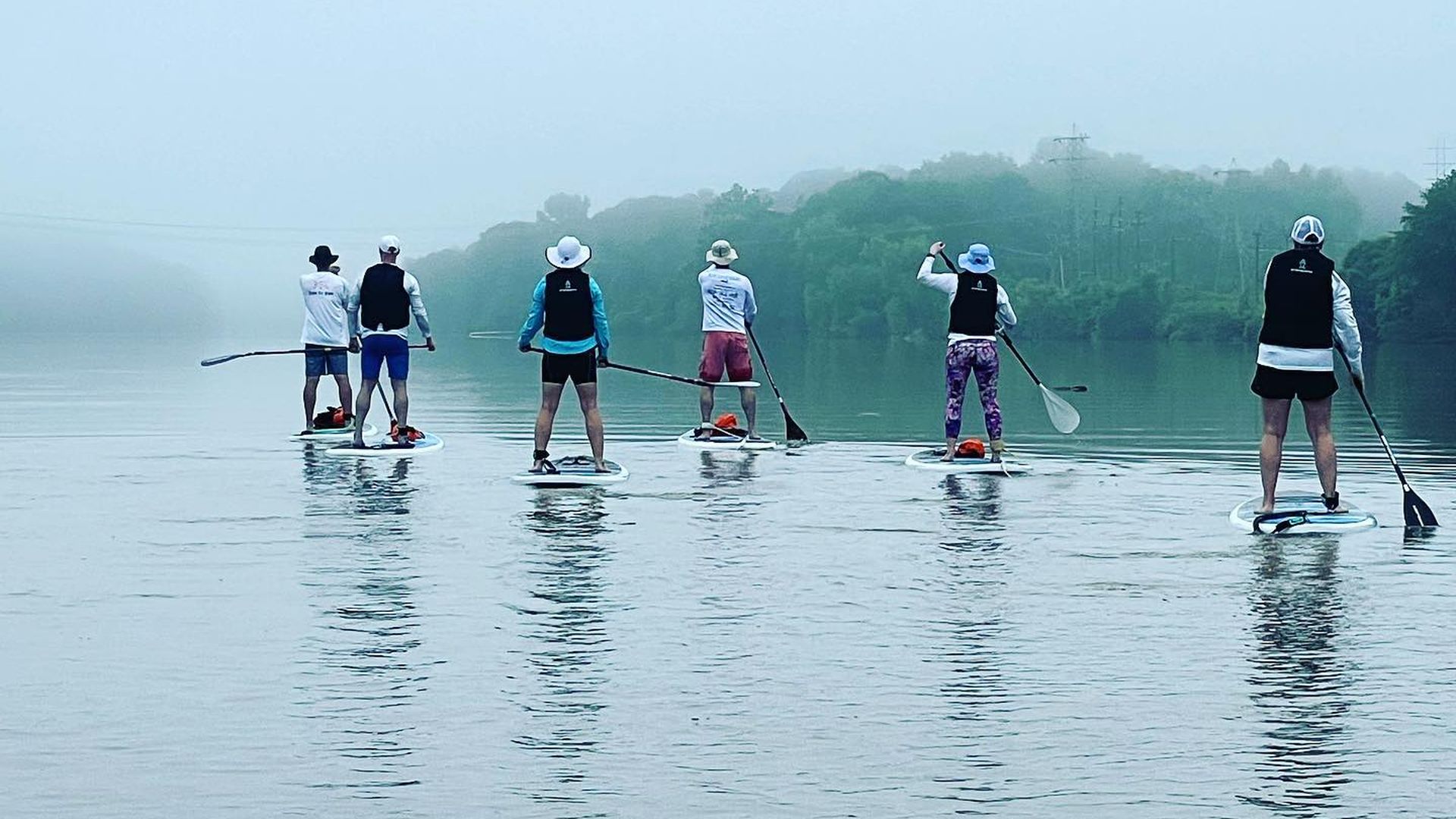 People stand up paddleboarding down the Catawba River.