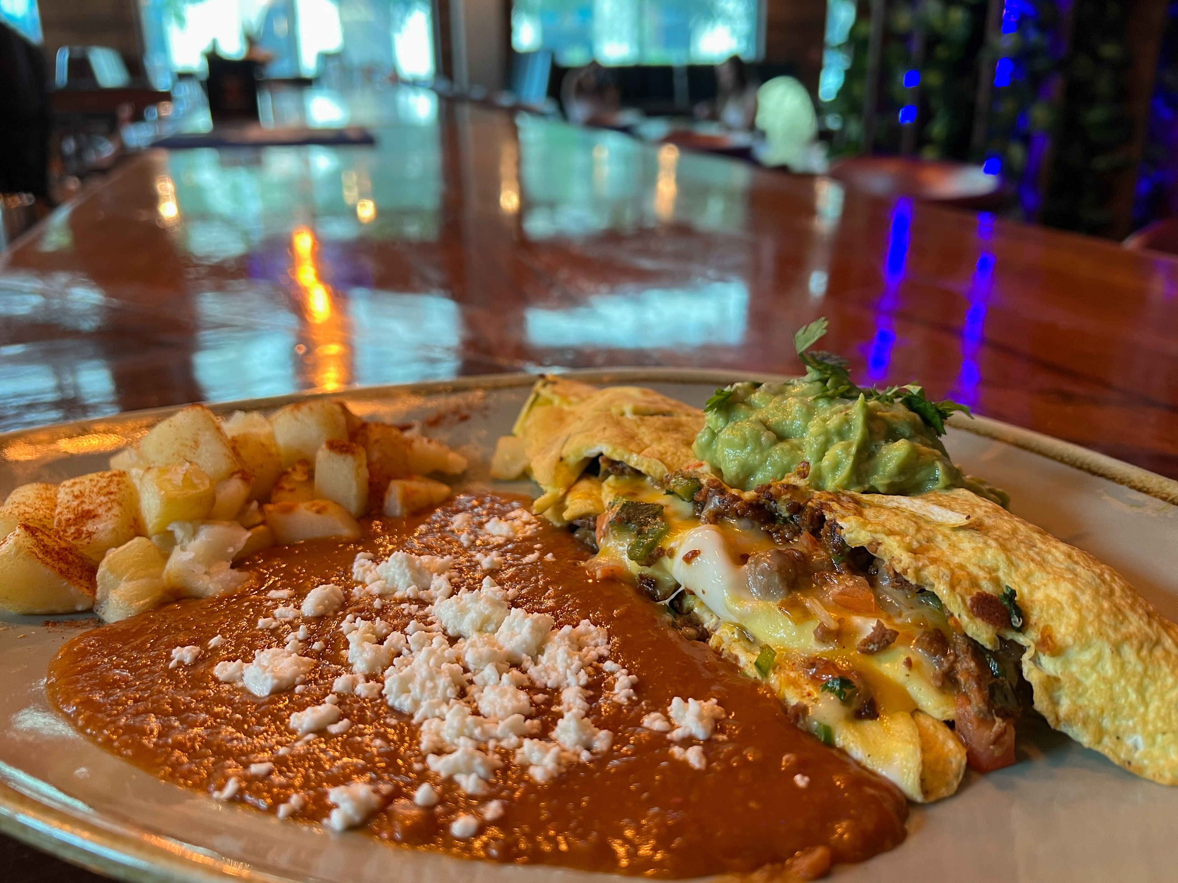 A plate featuring an omlette and salsa and cheese.
