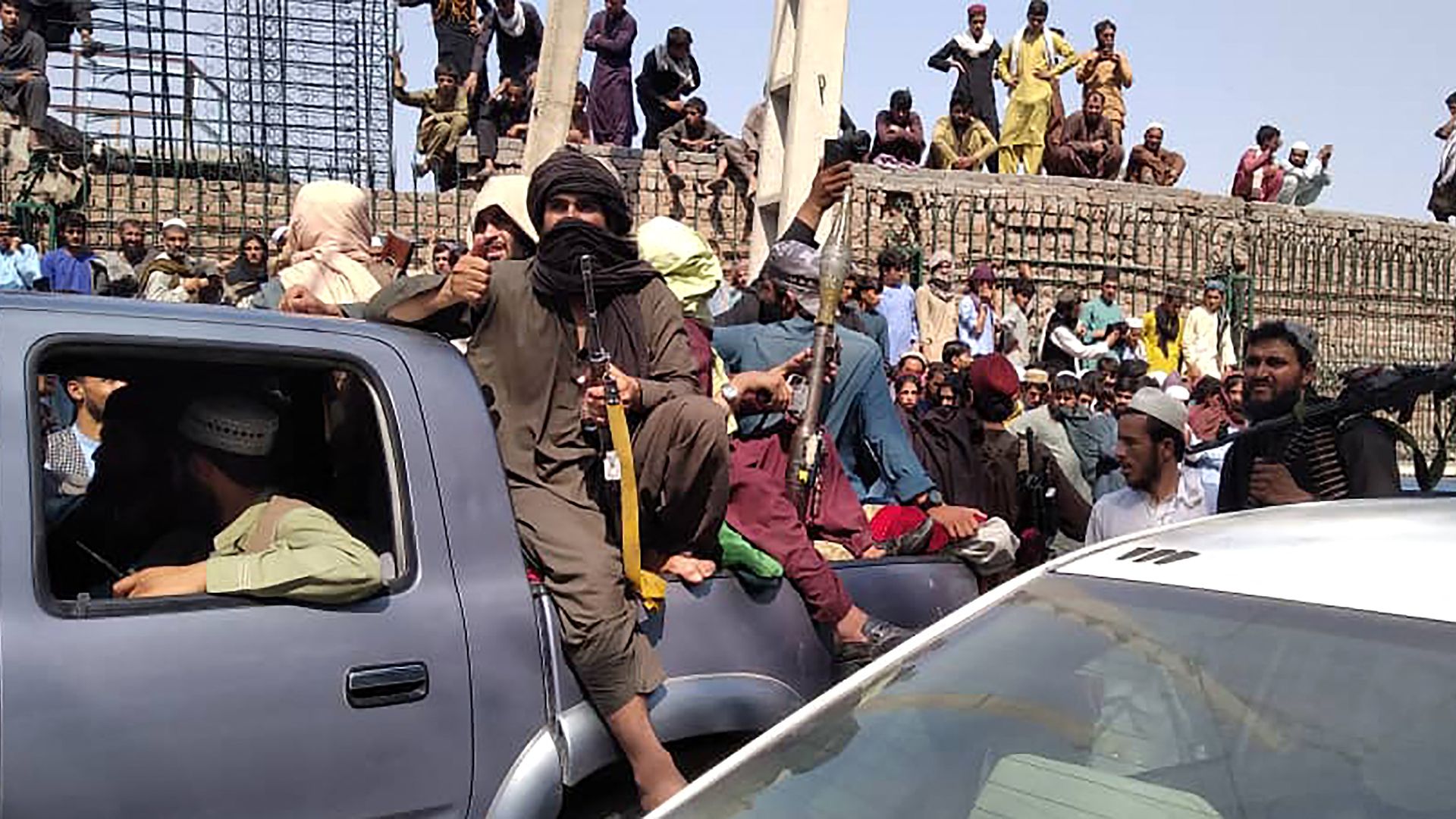 Taliban fighters sit on a vehicle along the street in Jalalabad province on August 15