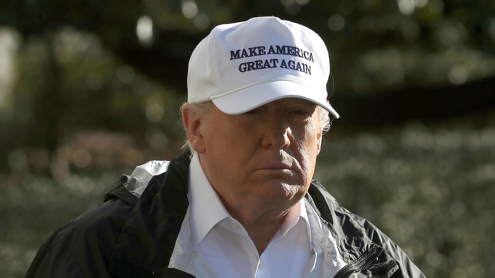 Donald Trump wearing a white "Make American Great Again" hat. 