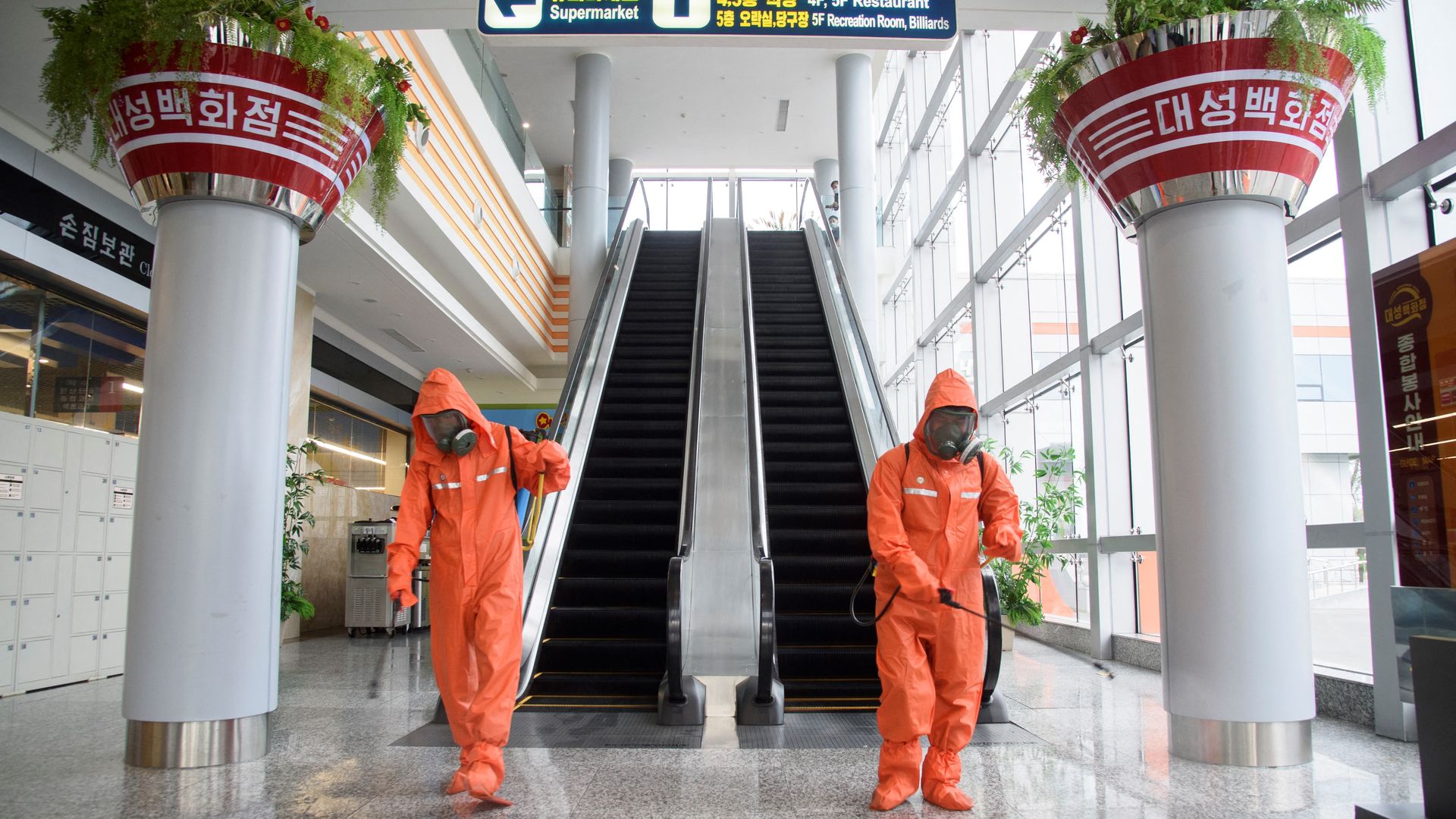 Health officials spray disinfectant as part of preventative measures against Covid-19, in the Daesong Department Store in Pyongyang on September 27