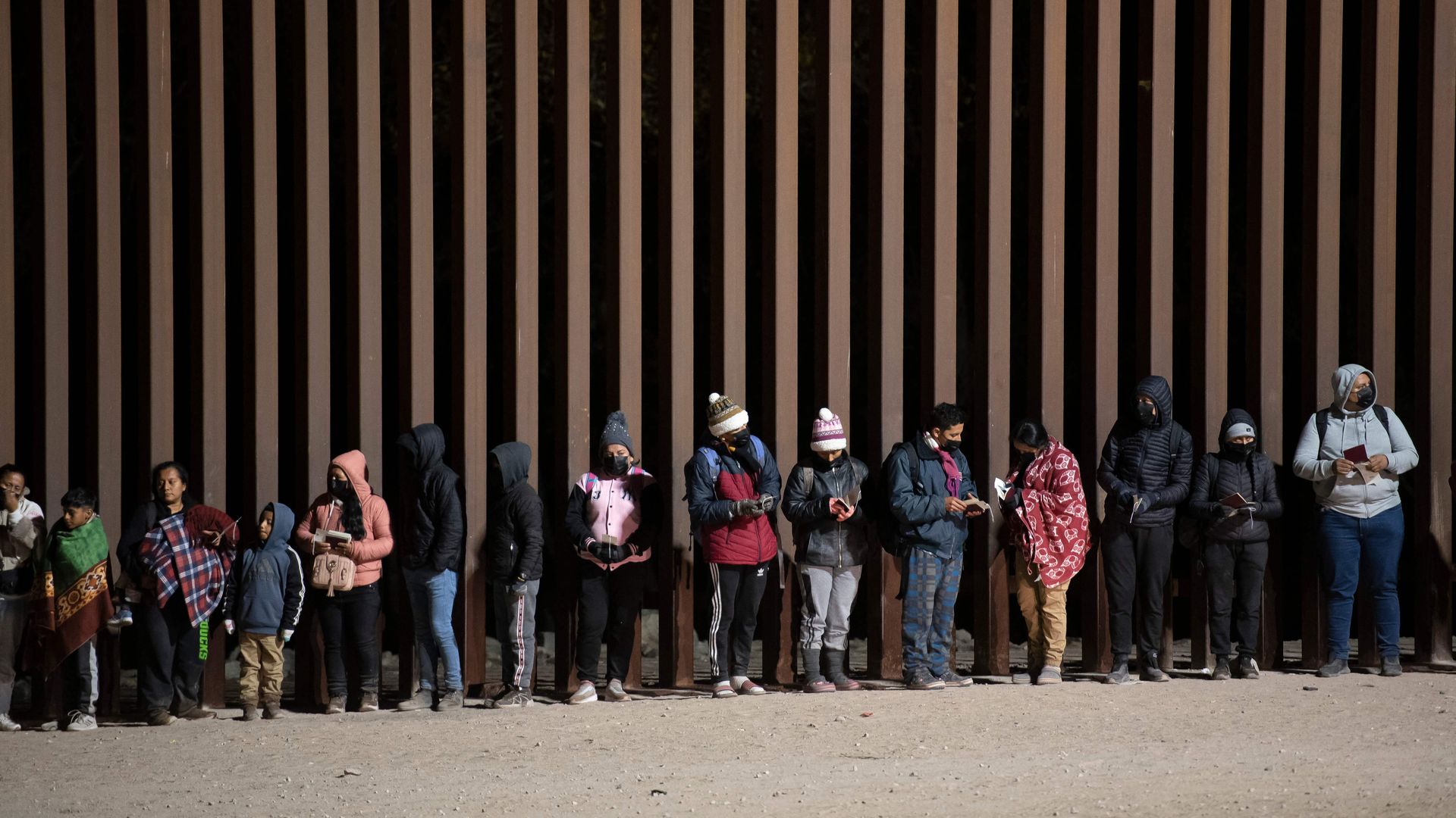 Asylum-seekers line up to be processed by U.S. Customs and Border Patrol agents at a gap in the US-Mexico border fence near Somerton, Ariz., on Dec. 26, 2022