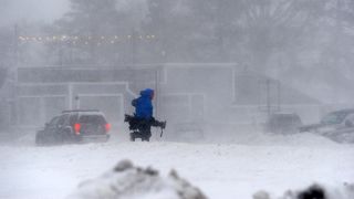     Members of the media battle snow and ice as the waters of Lake Erie rush onto the shoreline on December 23, 2022 in Hamburg, New York