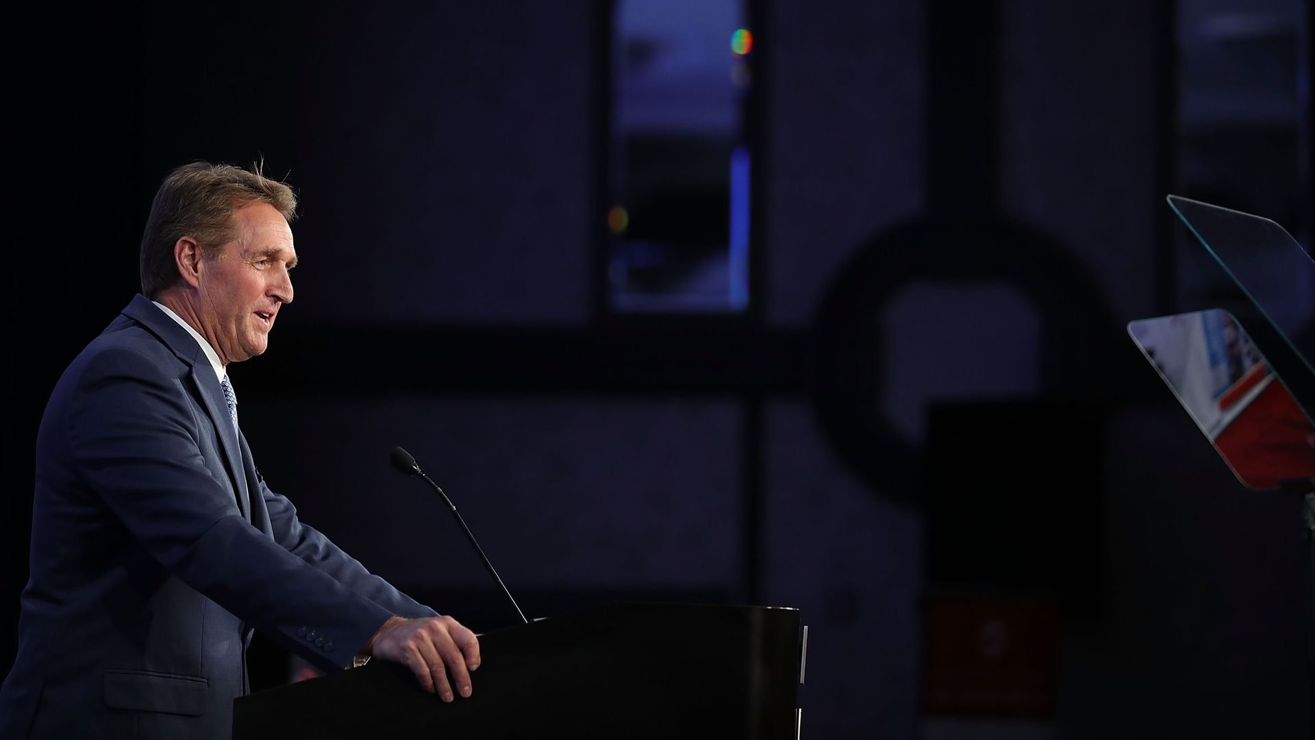 Jeff Flake speaking into a mic to the far left of the frame