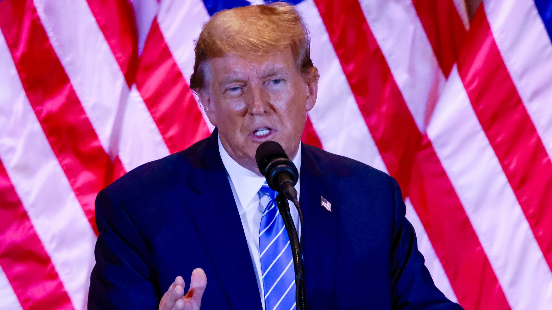 Former President Trump speaks into a microphone 