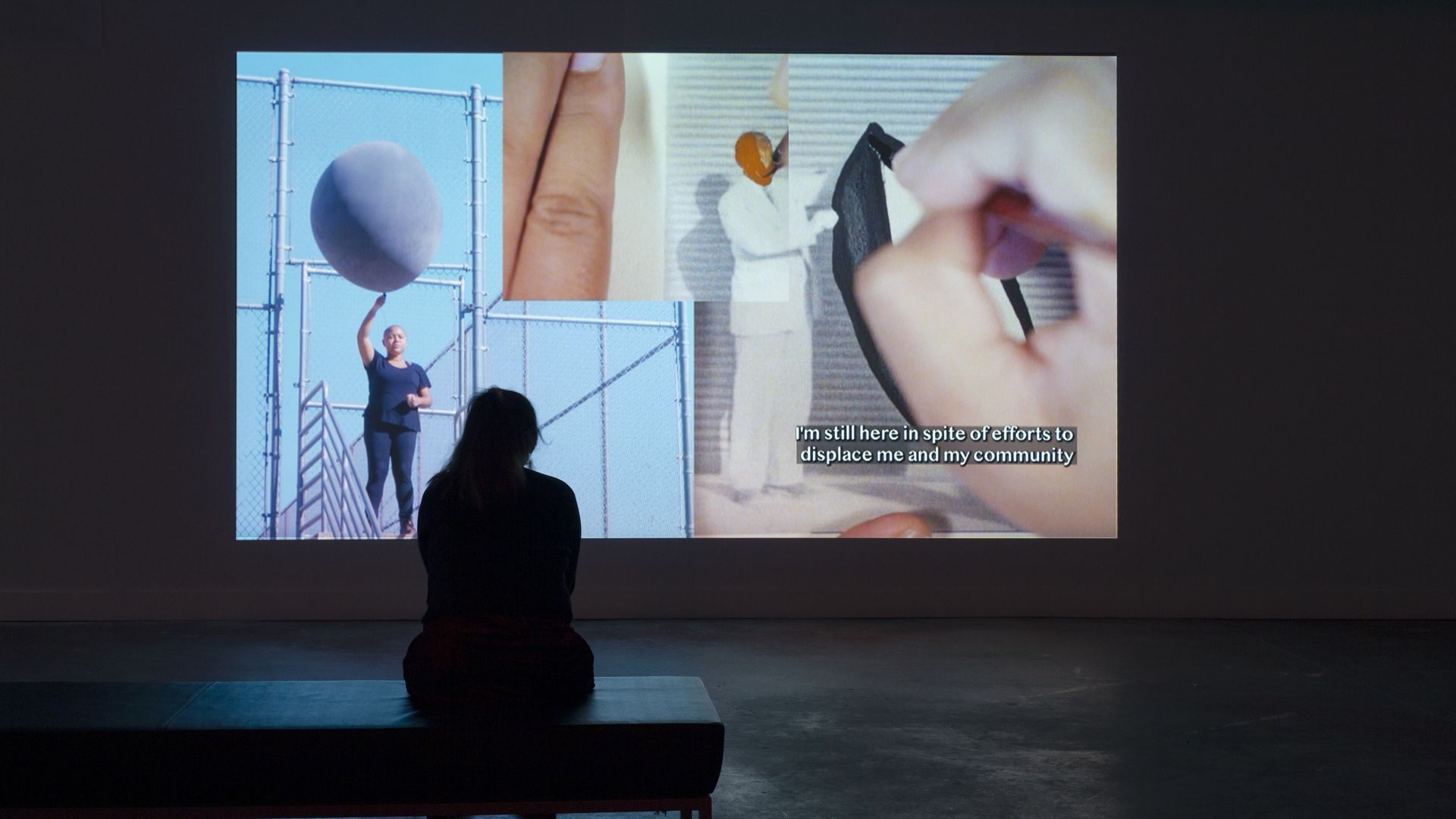 A viewer watches a video that's part of an art installation.