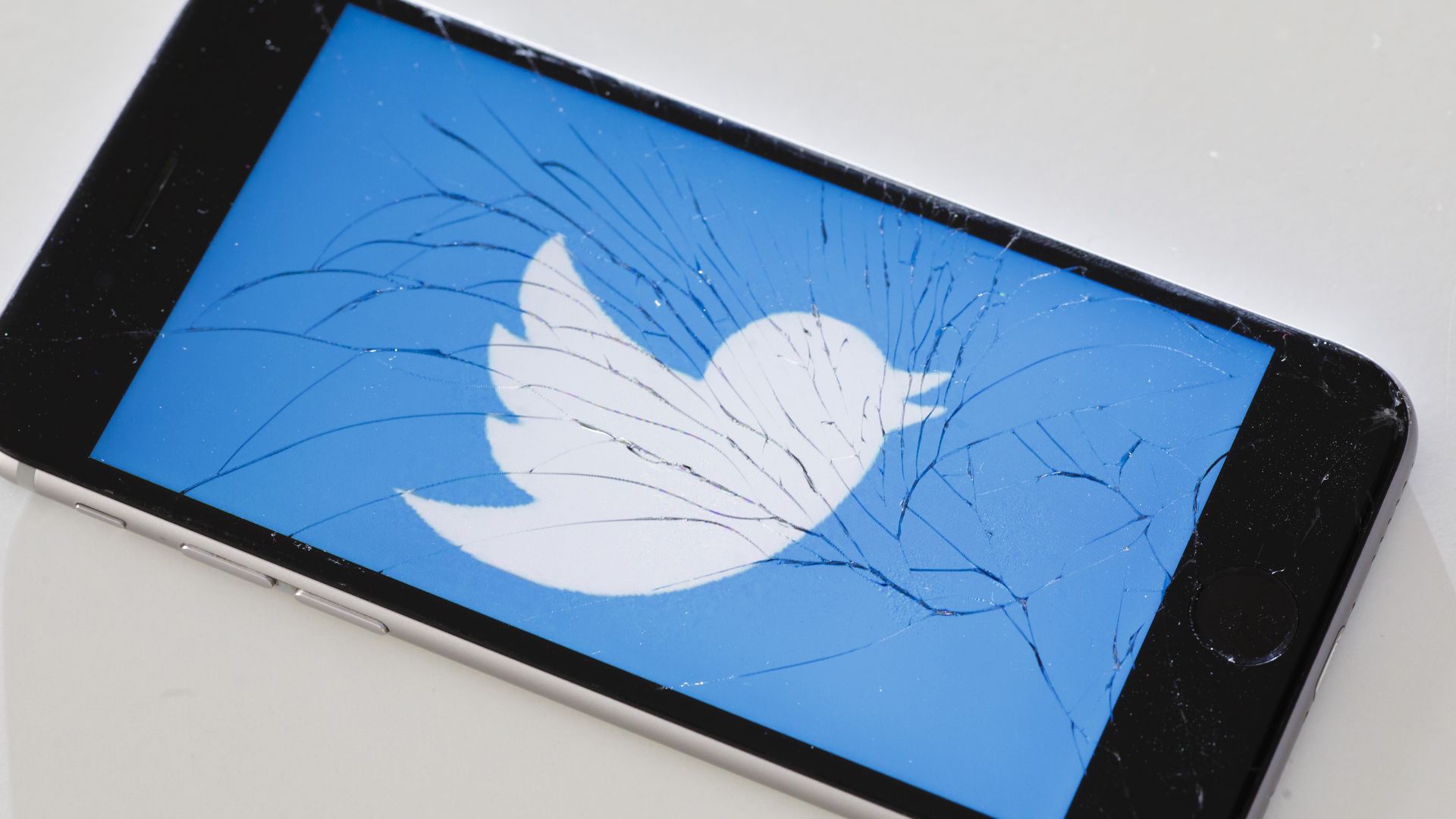 A broken phone showing the twitter logo