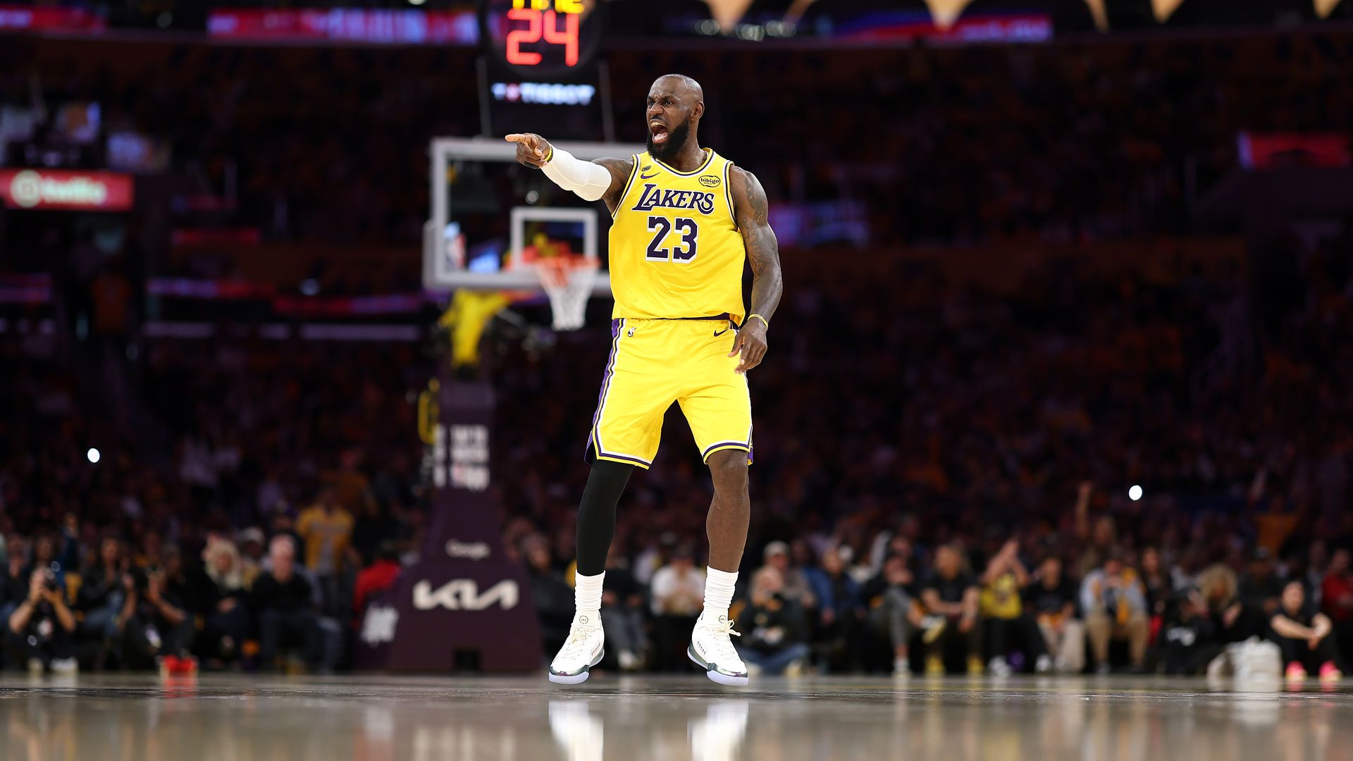 LeBron James in yellow jersey, pointing emphatically on court.