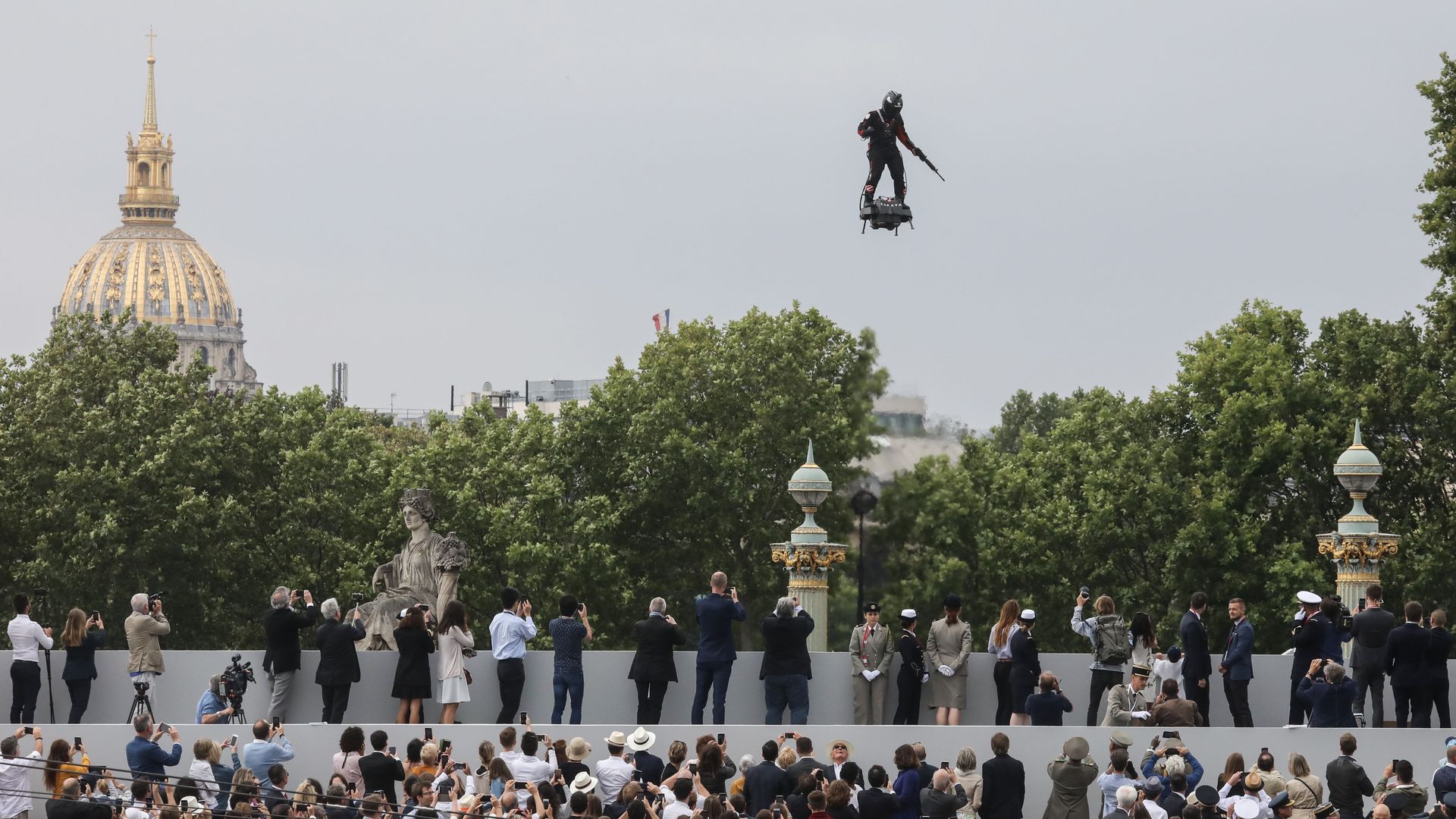 Image of soldier with a rifle on a flying hoverboard over France's Bastille Day parade