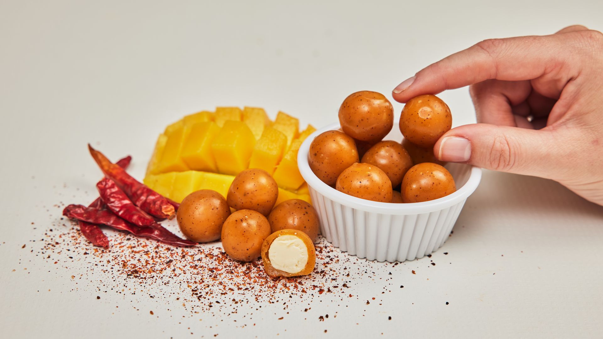 Bite-sized balls of cheese are wrapped in edible packaging.