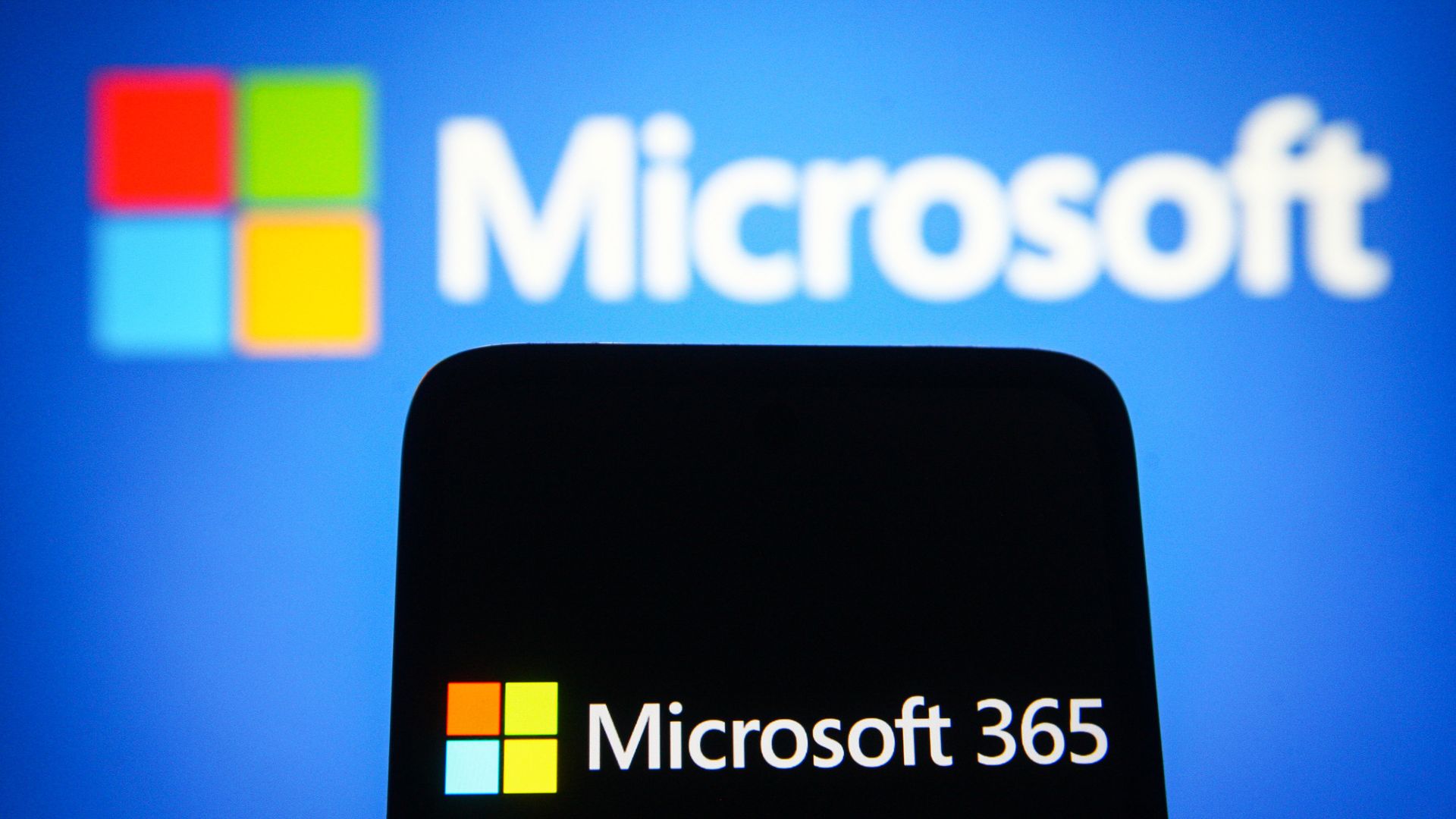 A Microsoft logo and a phone with a Microsoft 365 logo
