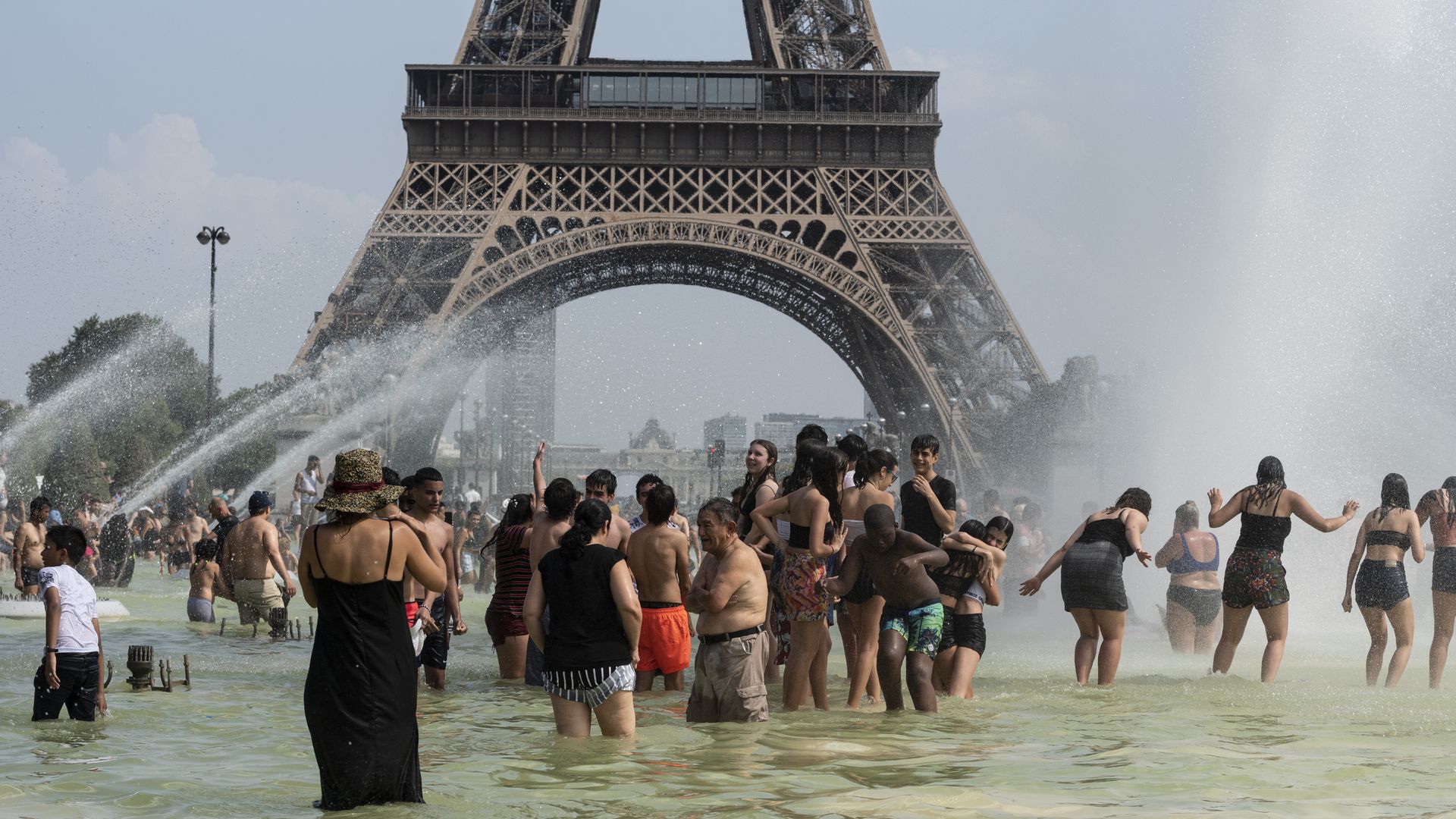 people swimming in water in front of the eiffel tower. 