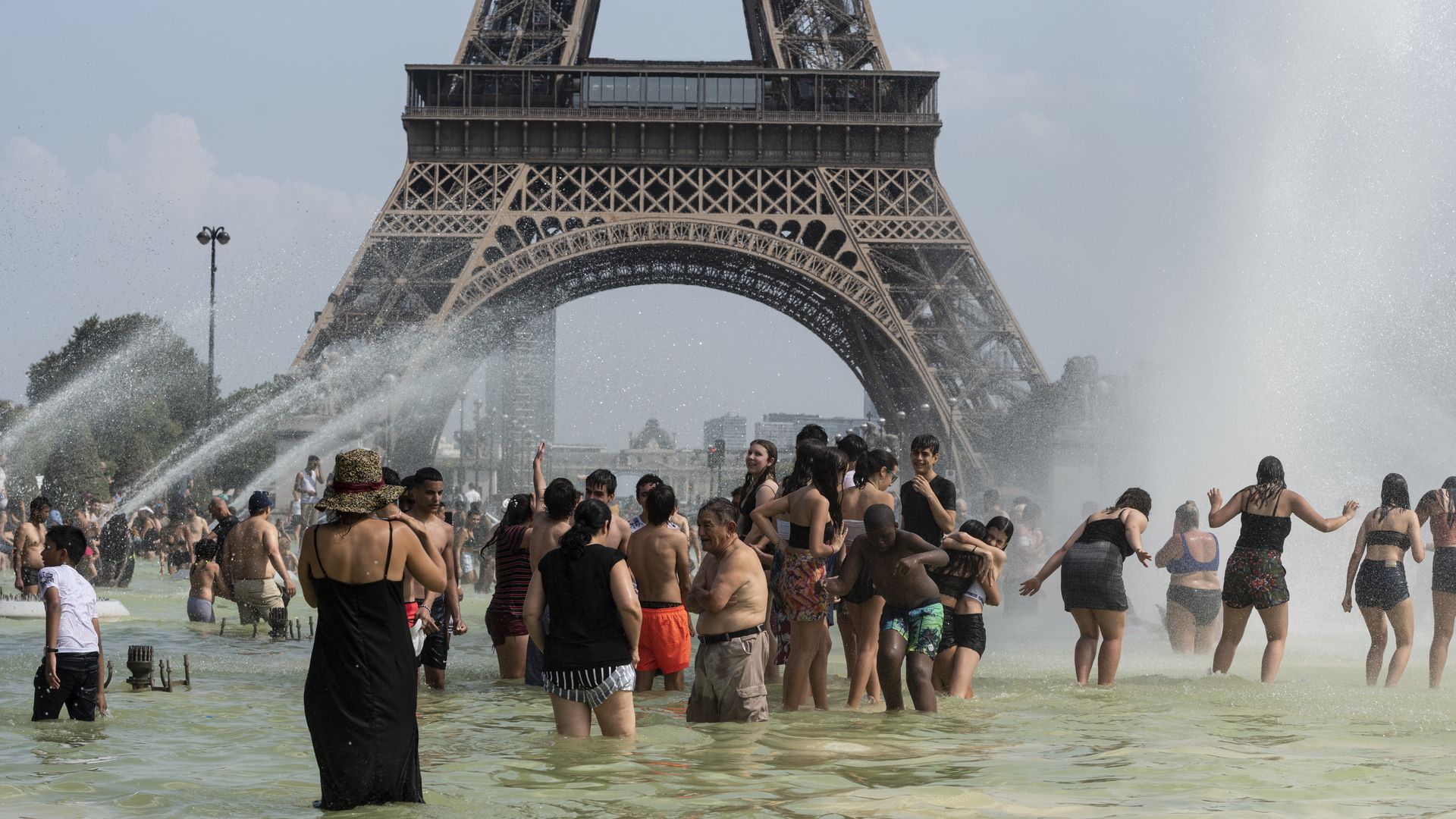 people swimming in water in front of the eiffel tower.