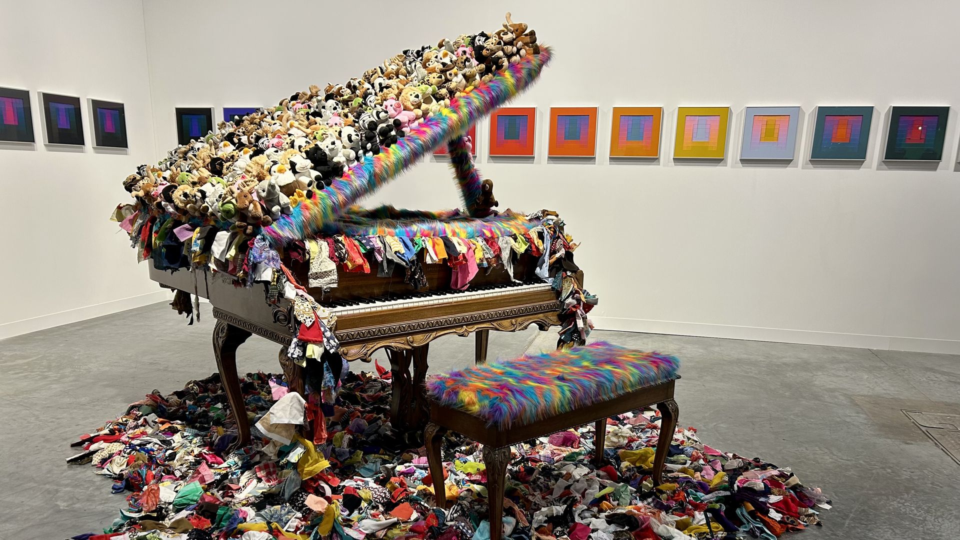 A piano covered in stuffed animals at Art Basel. 