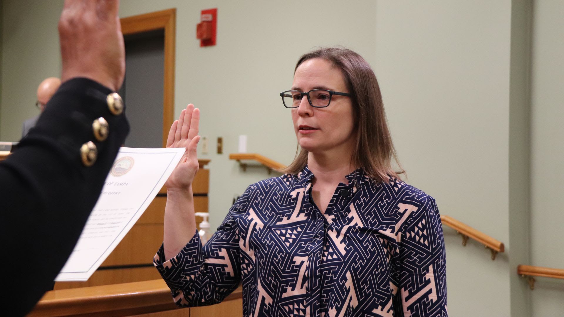 A photo of Lynn Hurtak, wearing glasses and a blue and pink blouse, as she's sworn in to Tampa City Council.