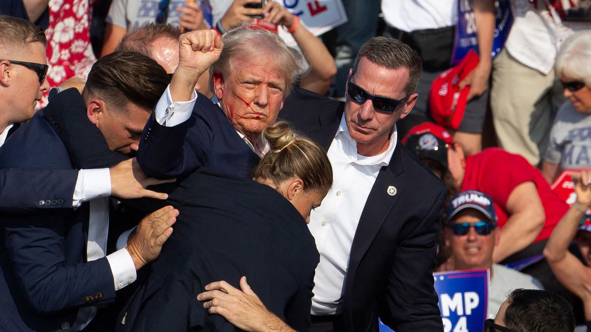 Then-Republican candidate Trump is seen with blood on his face surrounded by secret service agents as he is taken off the stage at a campaign event at Butler Farm Show Inc. in Butler, Pennsylvania, July 13, 2024. 