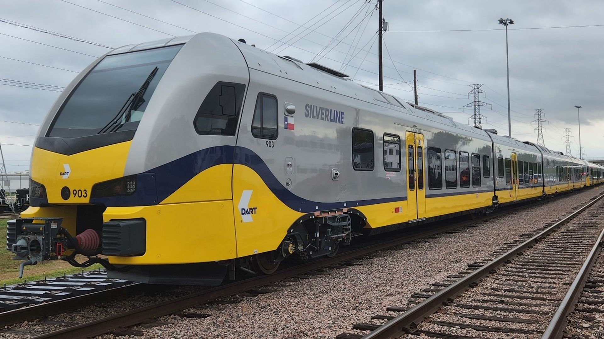 A gray and yellow train on tracks